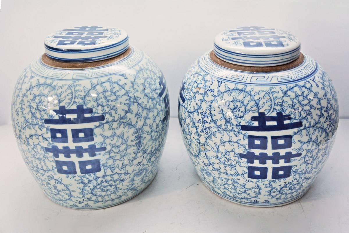 Pair of export blue and white ginger jars with lids from China. The color is the traditional cobalt blue on white. The Chinese lettering symbolizes double happiness.