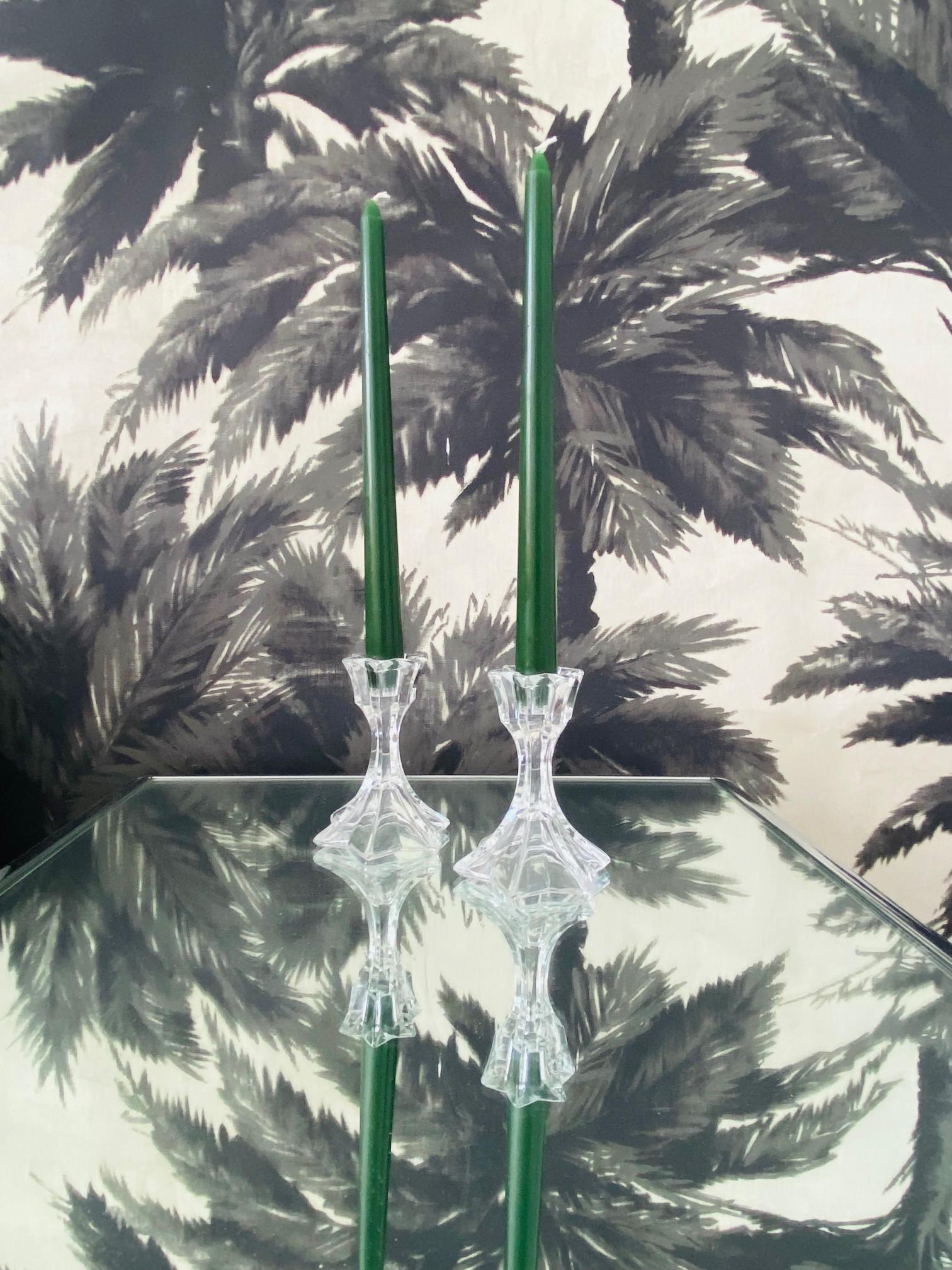 Ein Paar Kerzenhalter aus Bleikristall mit facettiertem Design aus der Jahrhundertmitte.  Die Kerzenhalter haben ein stilisiertes florales Muster, das an eine Lilie oder eine Iris erinnert, mit einer sechszackigen Sternformation entlang der Schalen