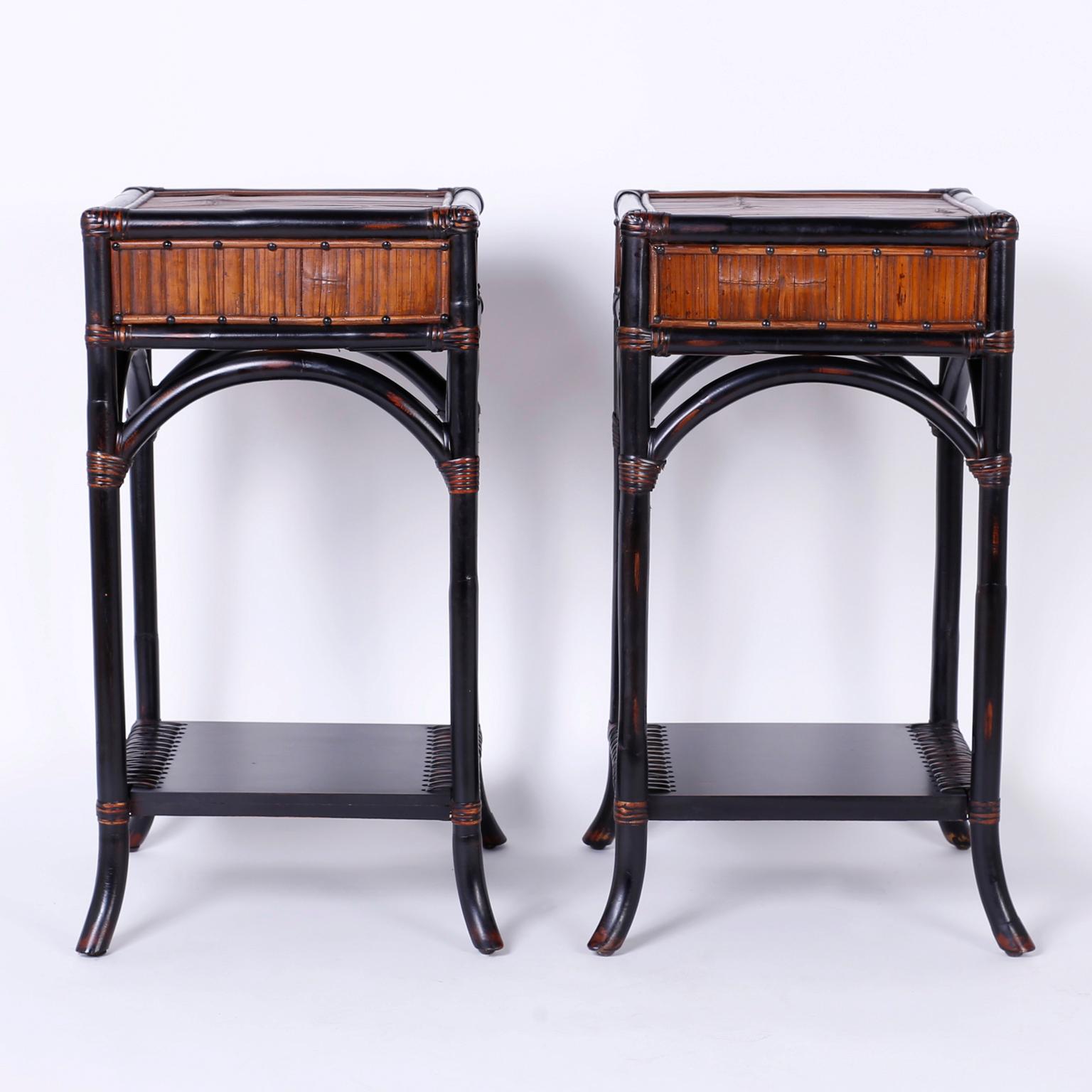 Handsome pair of vintage faux bamboo and rattan stands or tables with rattan tops and sides with wrapped corners, bentwood frame construction, and chic contrived wear. Perfect combination of modern and traditional British Colonial.
 