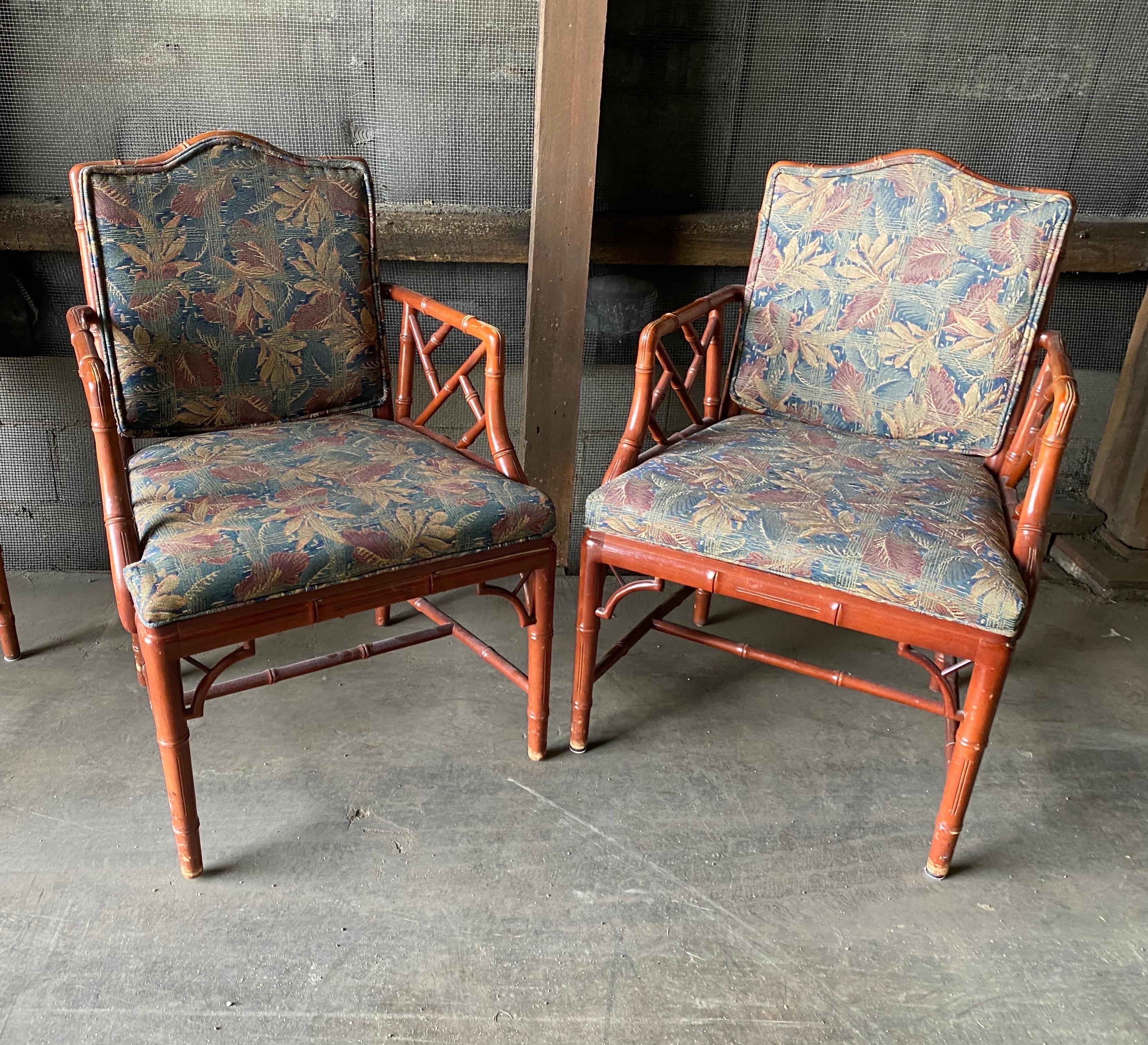 Pair of vintage faux bamboo arm chairs. 2 pairs available. Fabric in good condition- back cushion can be removed to show the faux bamboo instead.