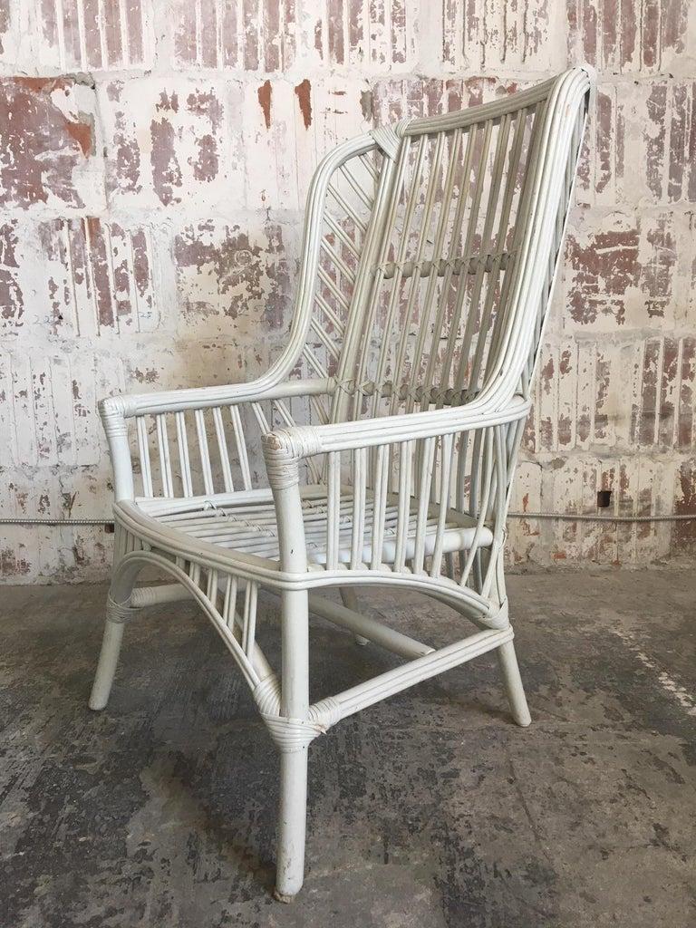 Pair of Ficks Reed high back chairs in white rattan. Definite statement pieces for any decor, indoor or out. Very good structural condition with minor abrasions to the as-found finish. Seat cushions have minor stains.
Measures: Seat height 15