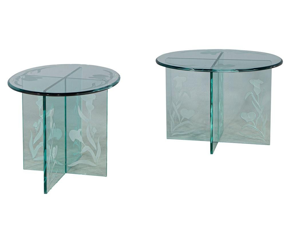 Pair of vintage floral etched glass oval end tables. Stunning floral sandblasted design in thick tempered glass. Oval top with beveled edge and cross pedestal design. Original piece from America circa 1970's. Price includes complimentary curb side