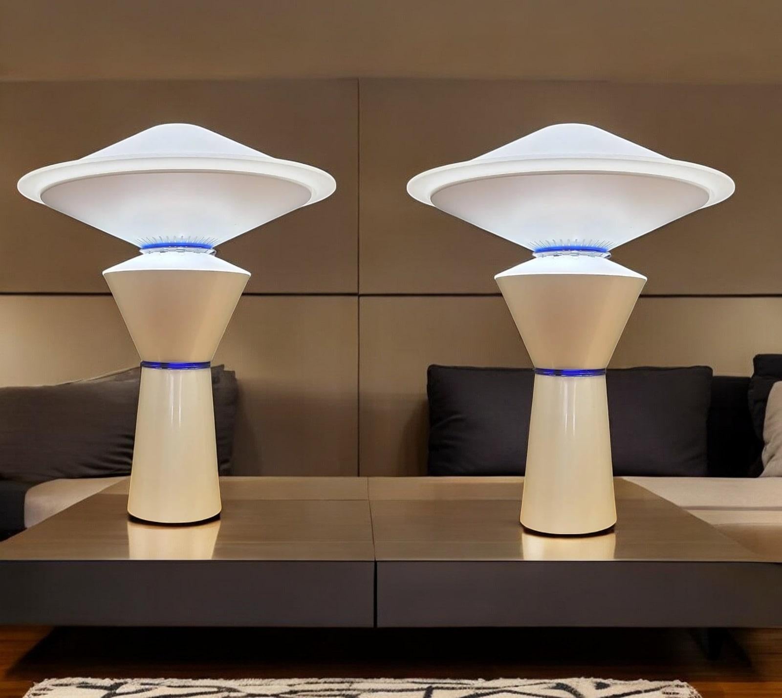 Pair of Post-Modern table lamps designed by Pier Giuseppe Ramella for Arteluce and manufactured by FLOS of Italy. With frosted glass shades and a tapered weighted enamel base.  They can be lit using two bulbs to illuminate either low or full light.