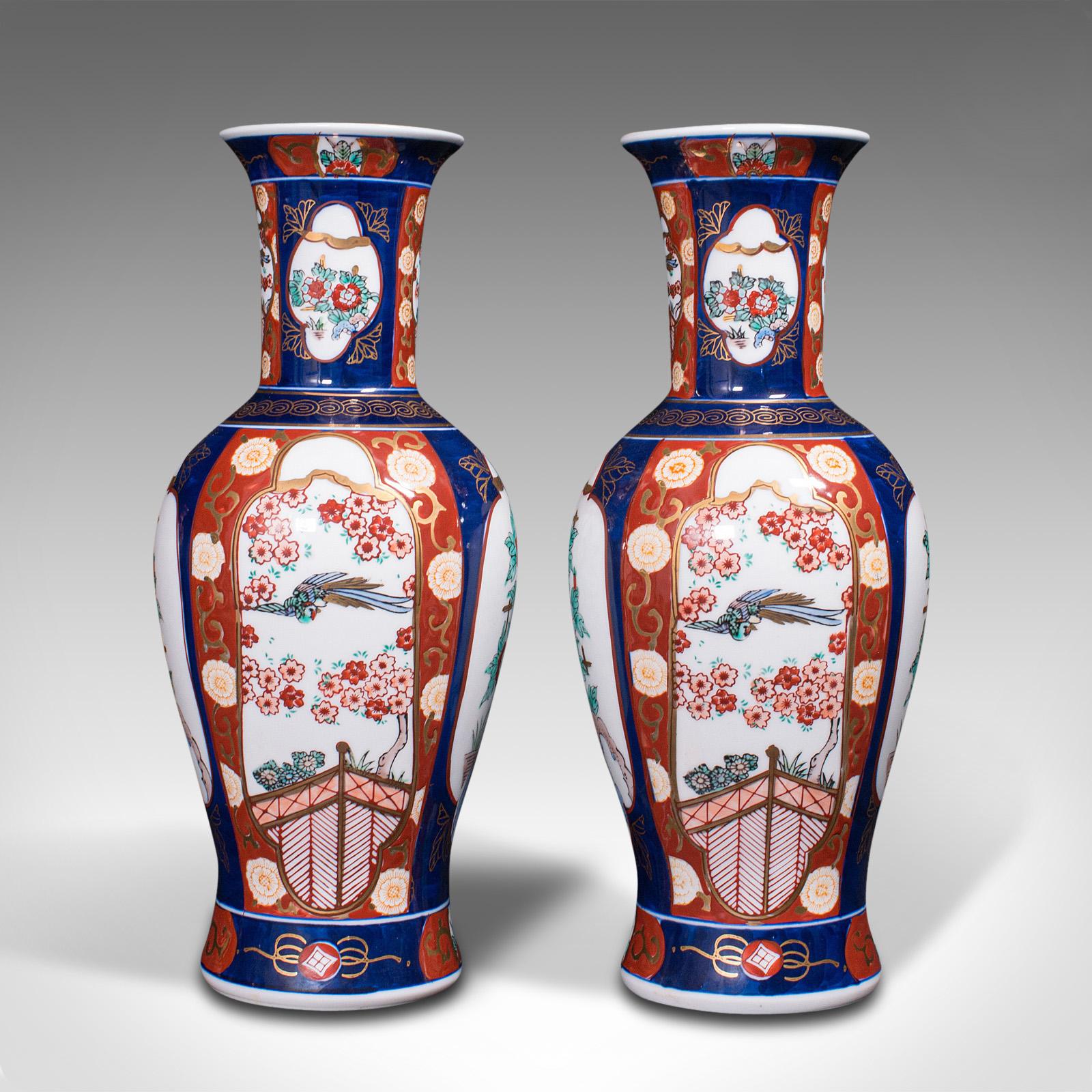 This is a pair of vintage flower vases. A Chinese, ceramic display urn in Imari revival taste, dating to the late 20th century, circa 1980.

Attractive red and blue palette a hallmark of Imari
Displaying a desirable aged patina and free of