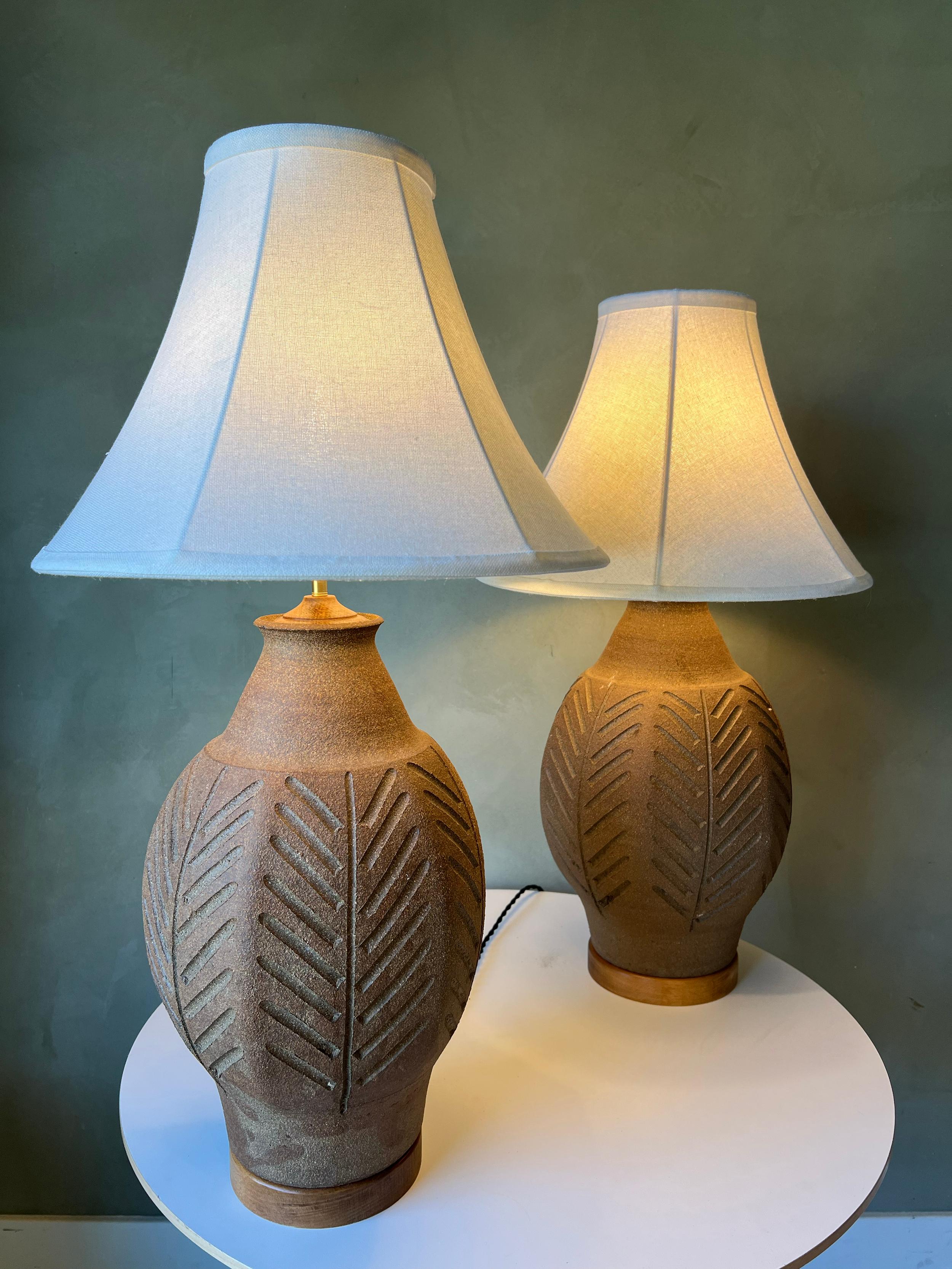 Ein Paar geriffelte Steingut-Tischlampen des kalifornischen Modernisten Brent Bennett. Diese Lampen wurden neu verkabelt, haben neue Leinenschirme und sind sofort einsatzbereit. Schönes geriffeltes Muster, das die Vase umgibt. Keine Chips oder Risse