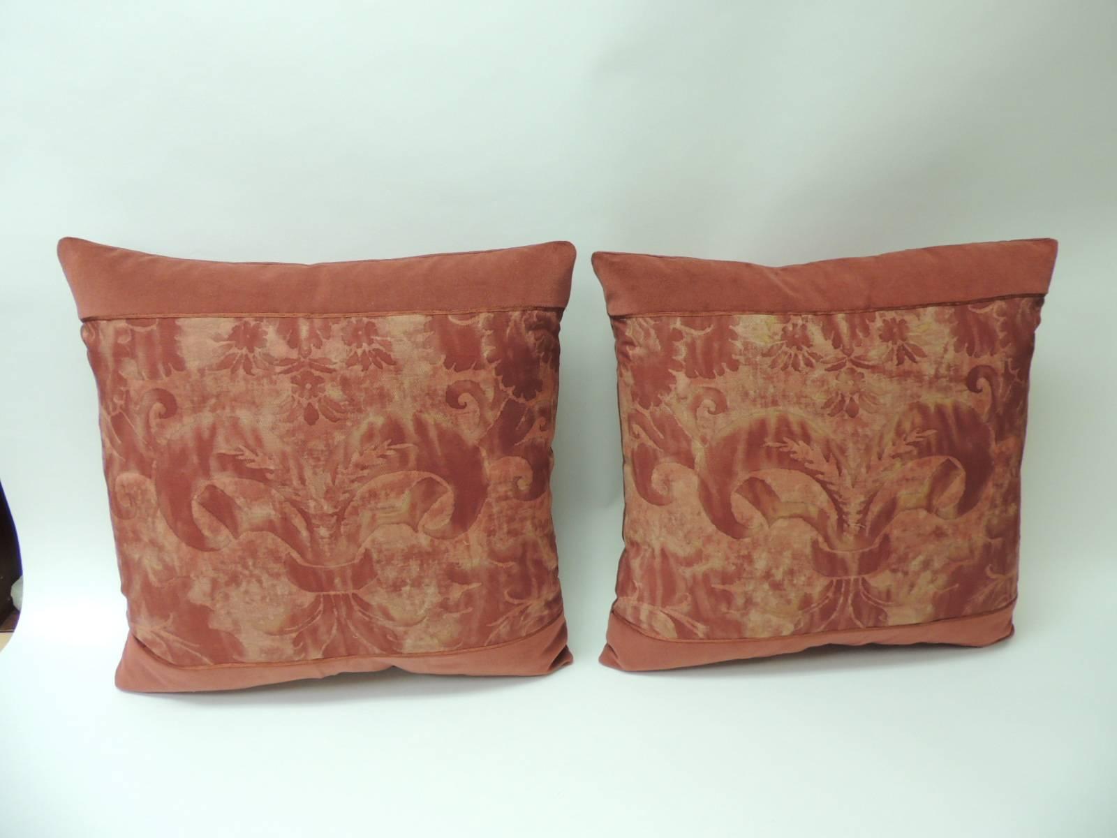 Pair of vintage Fortuny “Glicine” pattern red and silvery decorative square pillows. Framed with burnt orange cotton velvet and embellished with small silk orange trim at seams. Backed with red cashmere fabric. These pillows were designed using the