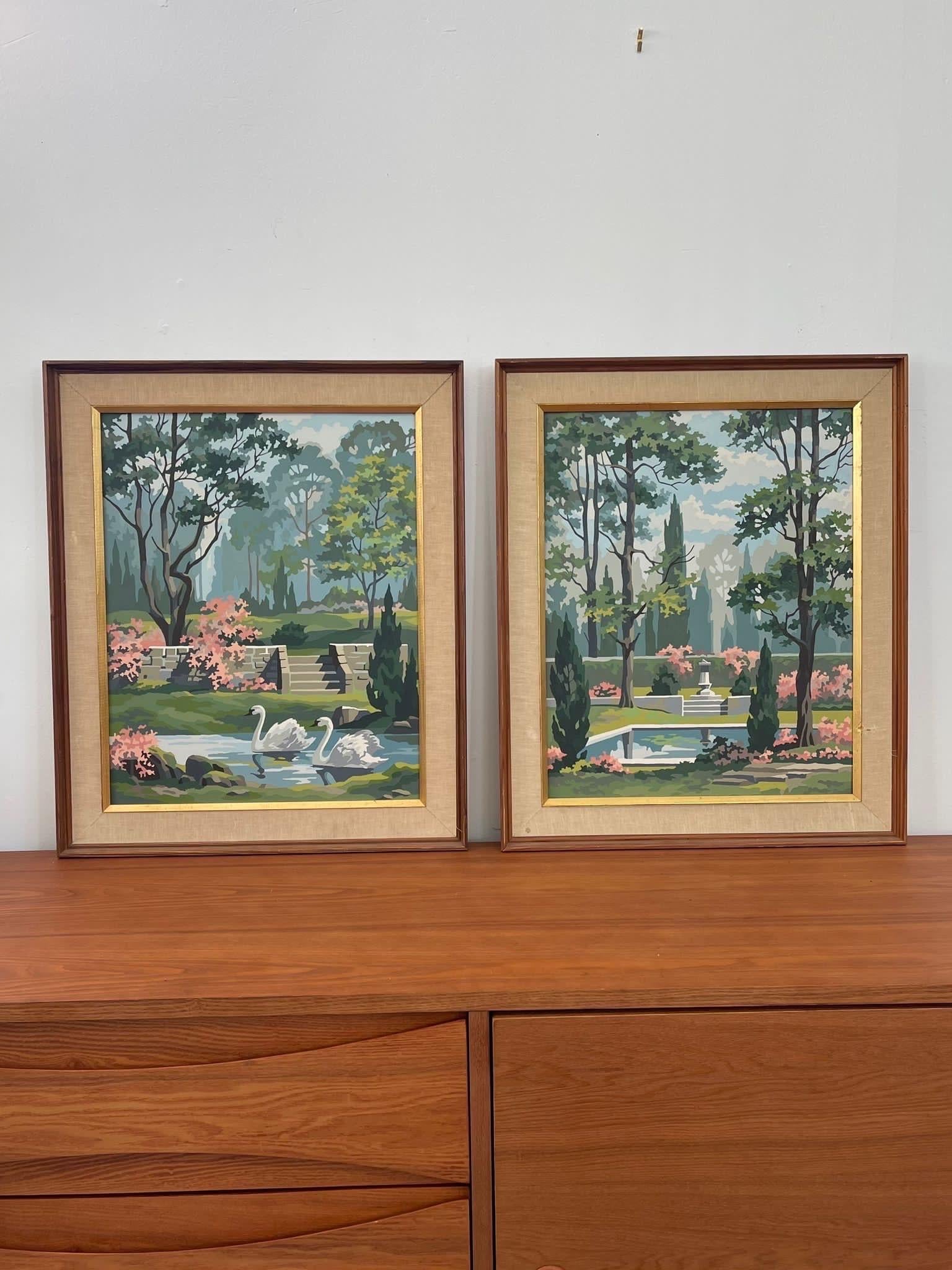 Coppia di quadri d'epoca con scene di giardino. Un dipinto raffigura un cigno e l'altro mostra un cortile. Sono complementari grazie agli accenti floreali rosa e agli stagni simili. Cornice in legno con accenti dorati. Condizioni vintage coerenti