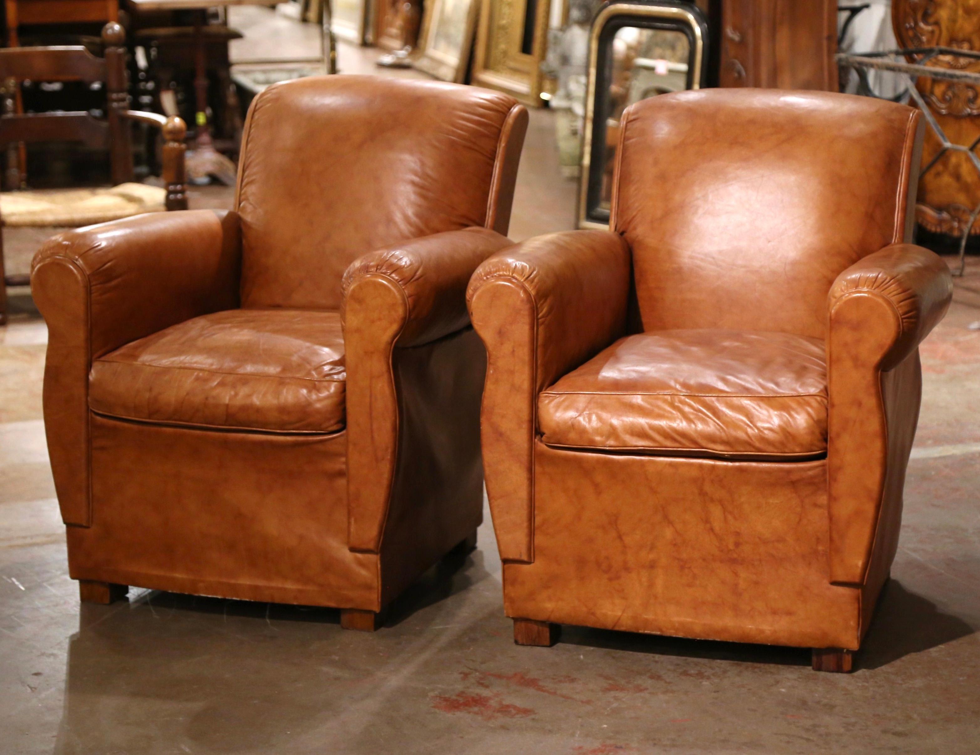 These classic, antique Art Deco club chairs were crafted in France, circa 1970. The stately chairs stand on square feet, and feature wide, rounded armrests, over an arched and rolled shape back. The Classic, masculine French chairs with loose