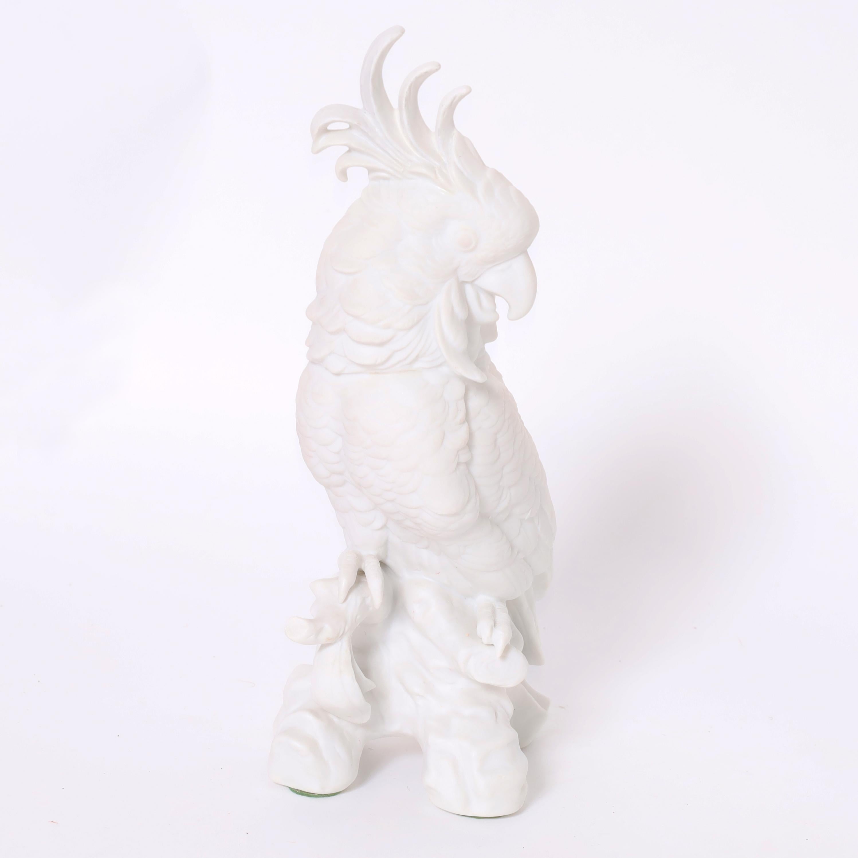 Striking pair of bird or cockatoo figures or sculptures crafted in bisque porcelain in stylized form perched on tree trunks. 