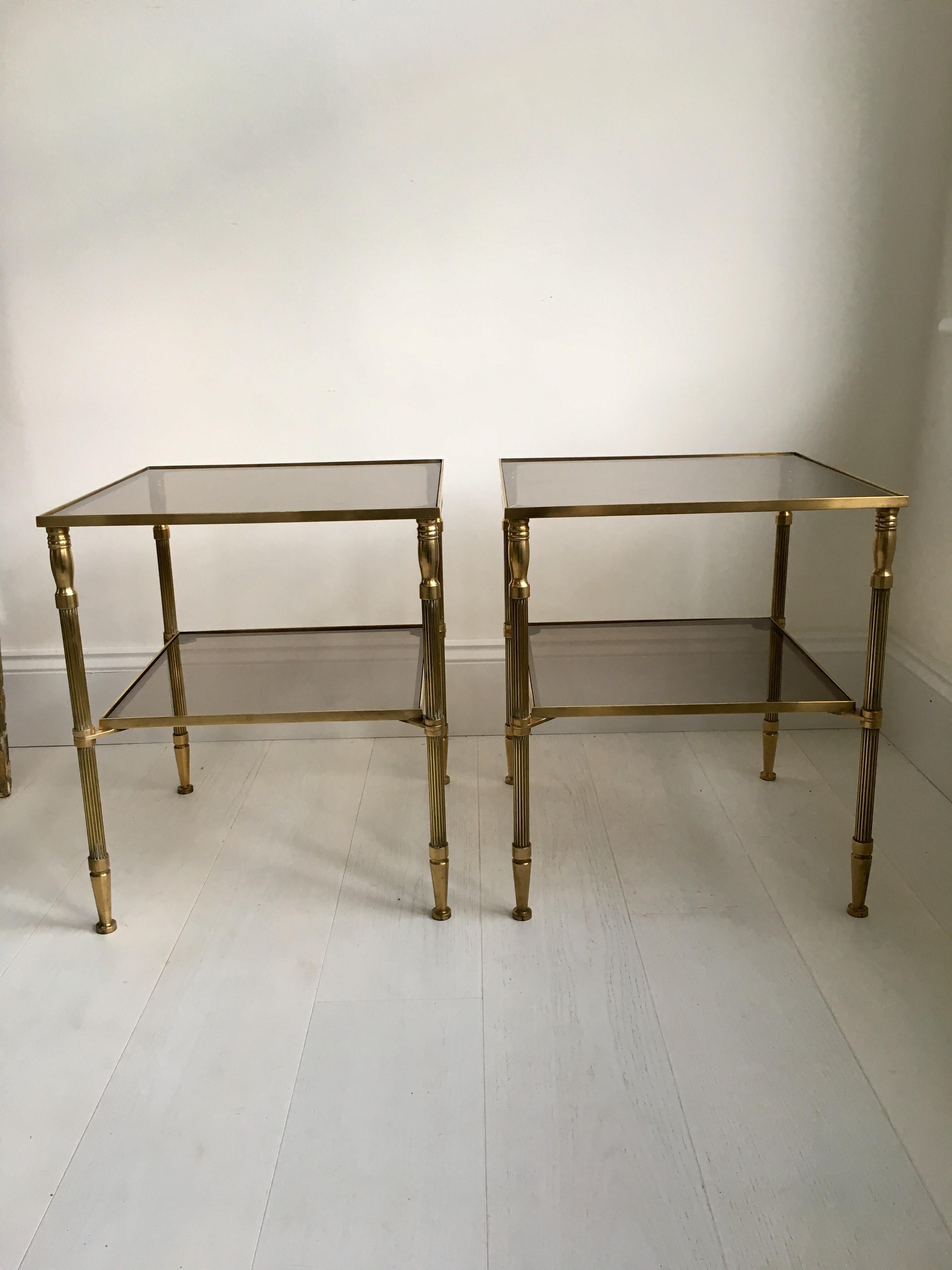 A great pair of 2-tiered polished brass side tables from France, circa 1970

Stands at 51cm with original smoked glass shelves

Measuring 43cm square.
 