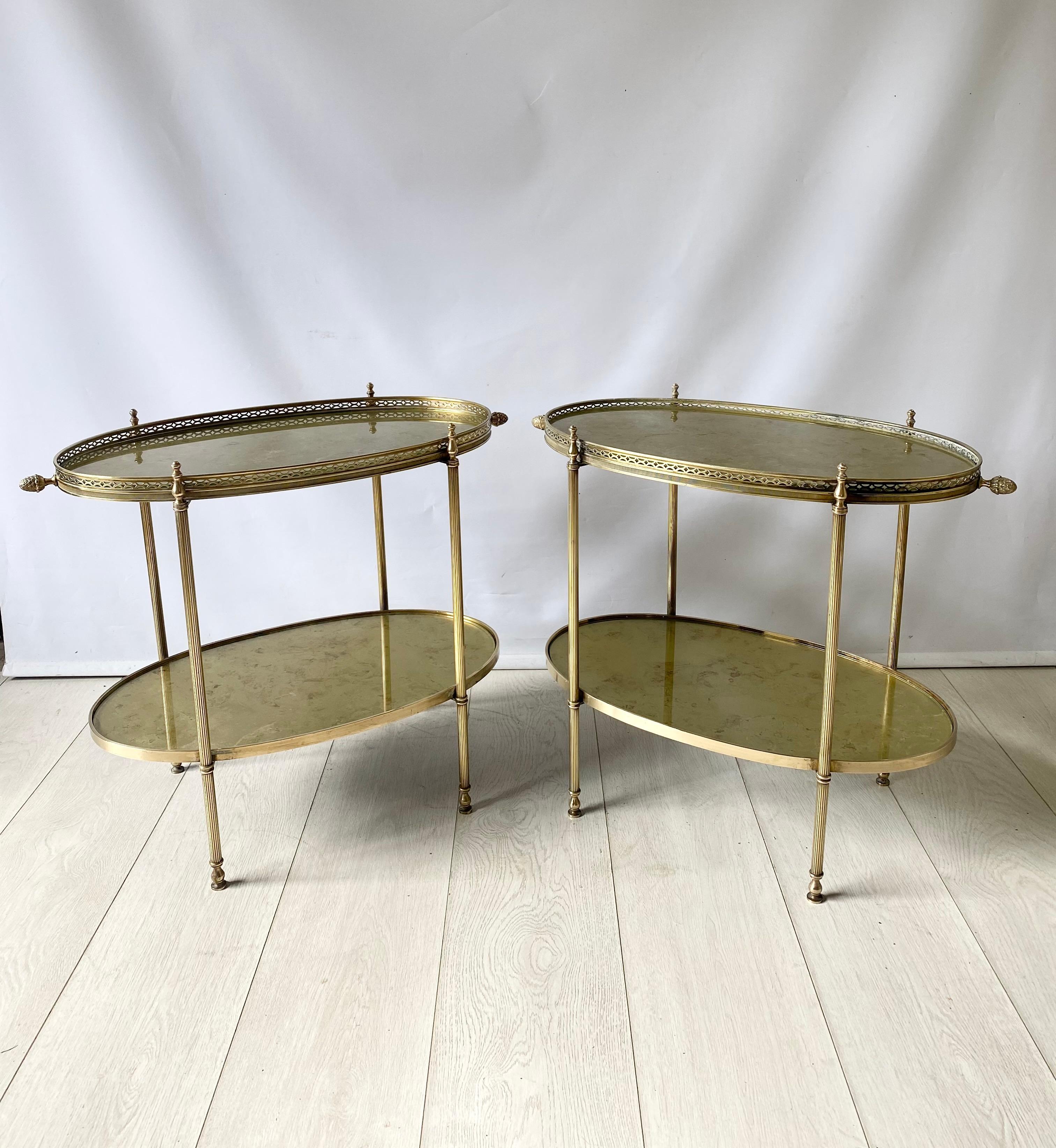 Exceptional pair of vintage brass side tables from France

Decorative finials to the sides, with golden eglomise glass tops

Top tray measures 53.5cm wide, 62cm with finials
31.5cm deep
Stands 49cm to glass, 52cm to finials.