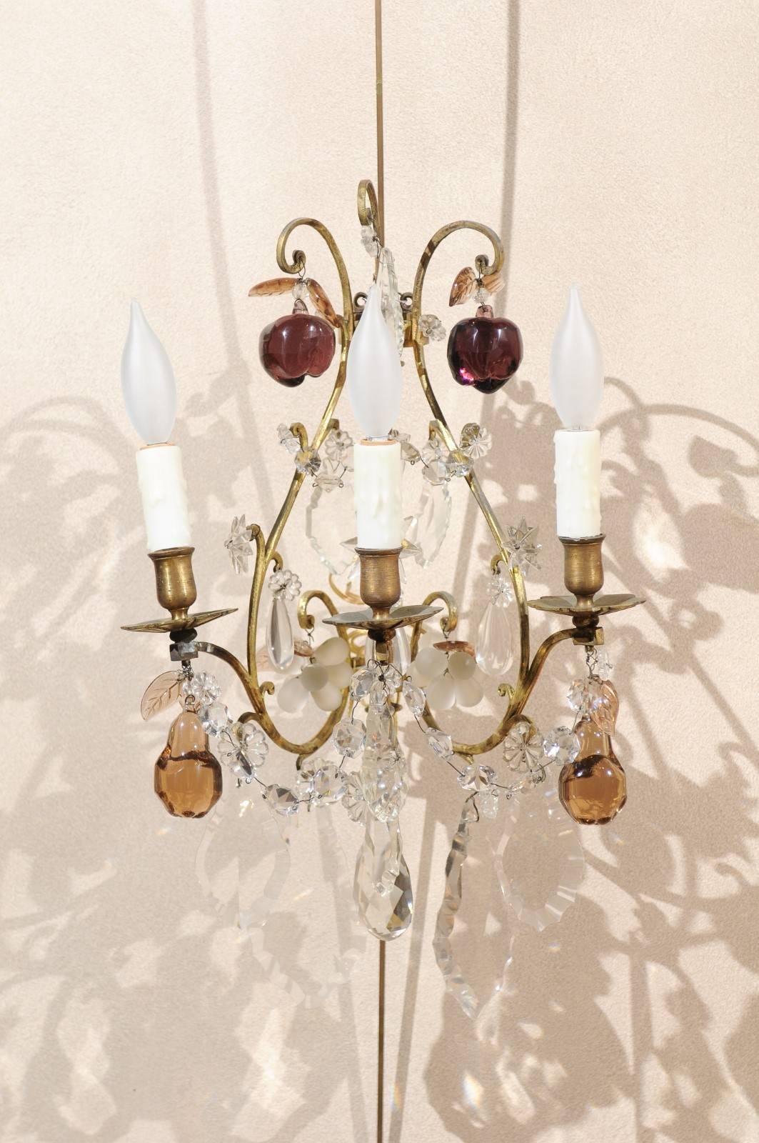 Pair of vintage French bronze and crystal sconces, circa 1950.
These sconces will catch your eye when you walk into a room. They have brilliant large crystals with a variety of small fruit on some arms. The elongated bronze inverted heart shape
