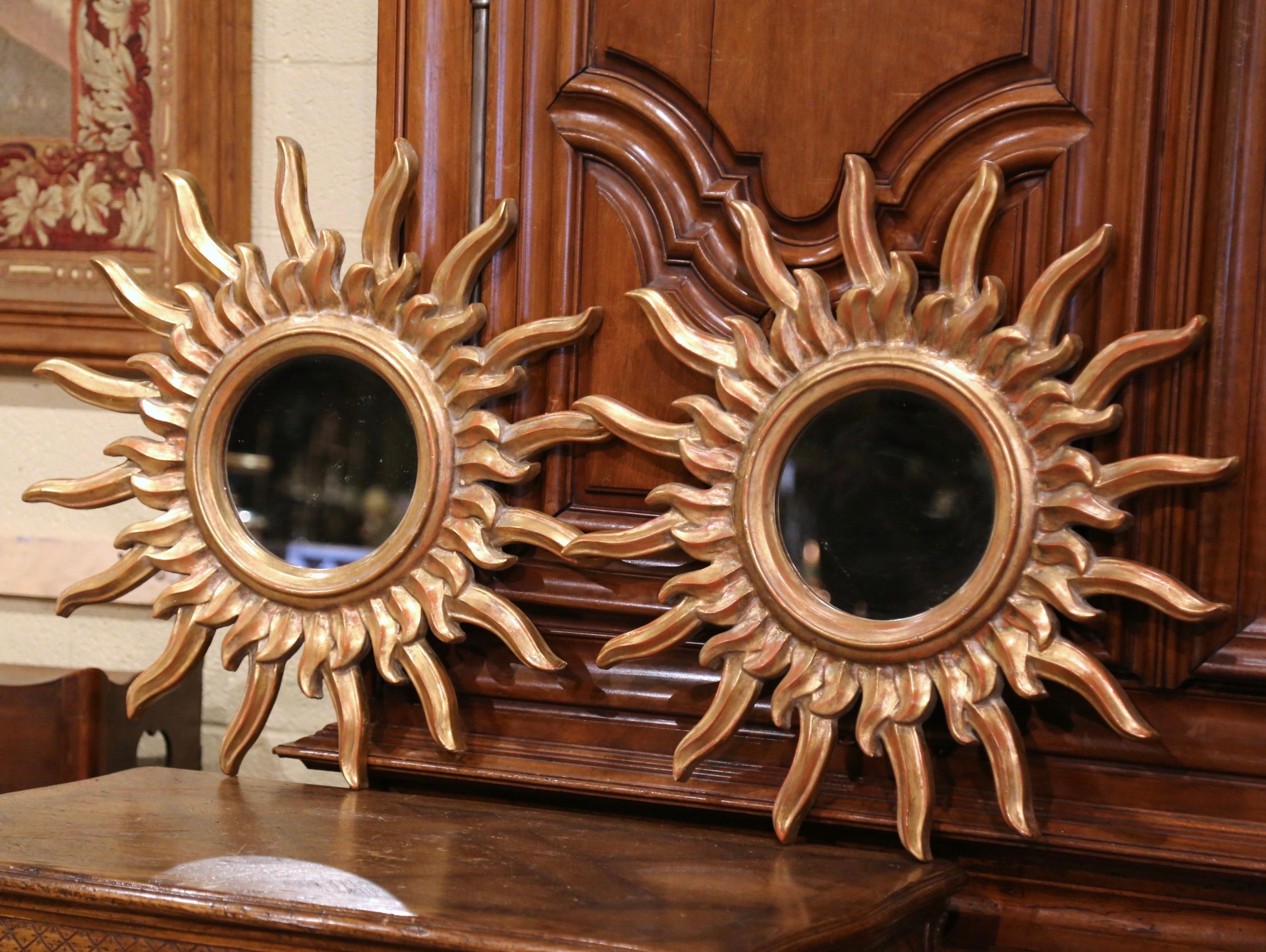 Add a beautiful shine to your home with this pair of eye-catching sun mirrors from France. Created circa 1970, the giltwood mirrors have a Classic sunbeam shape, a round glass in the center, and a rich rubbed gold leaf painted finish. In excellent