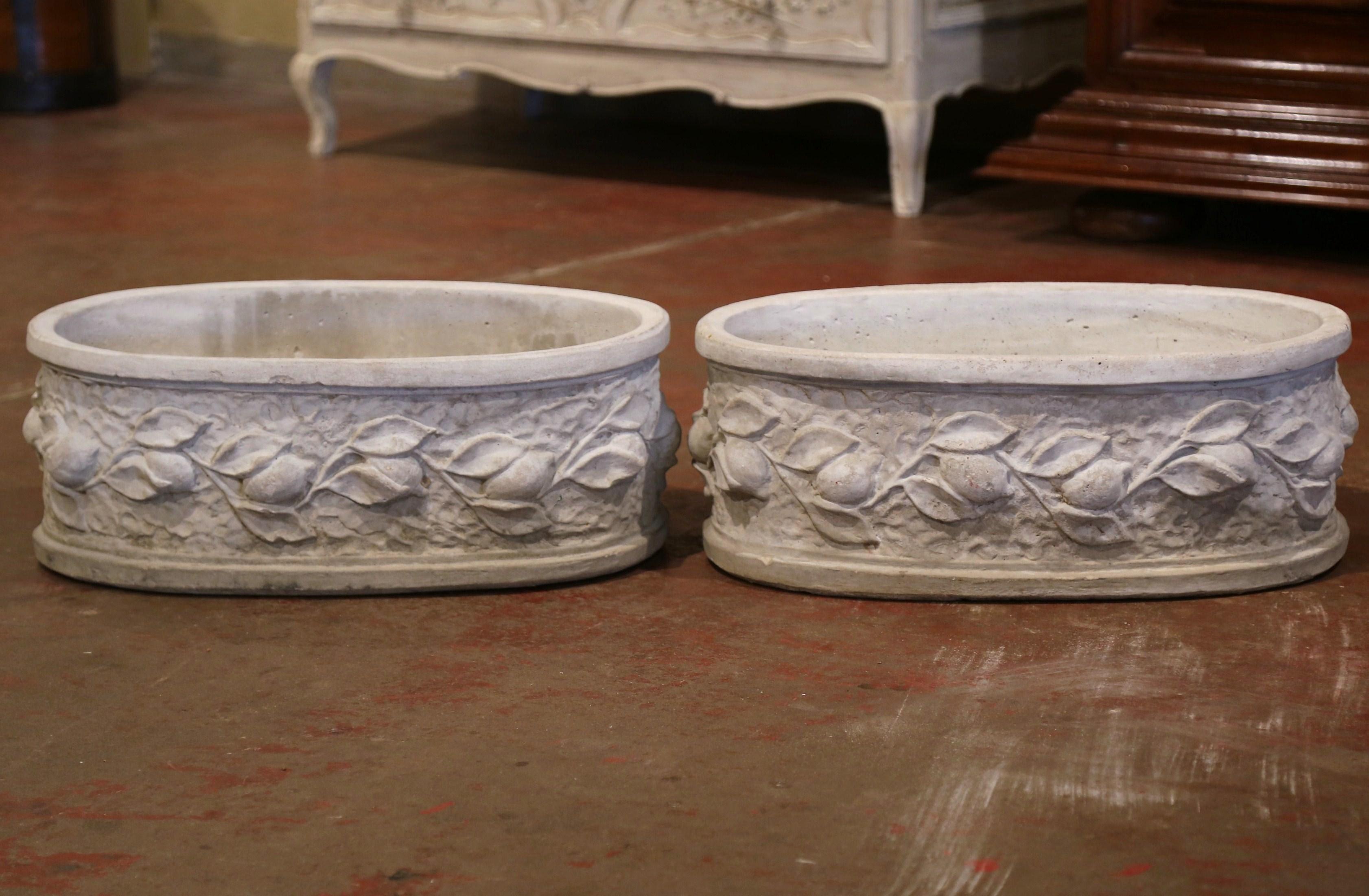 Decorate a patio with this pair of outdoor planters. Carved in Normandy France, circa 1990, each oval antique jardinière with drainage hole in the bottom, is decorated with high relief carved lemon fruit and leaf motifs all around the periphery. The