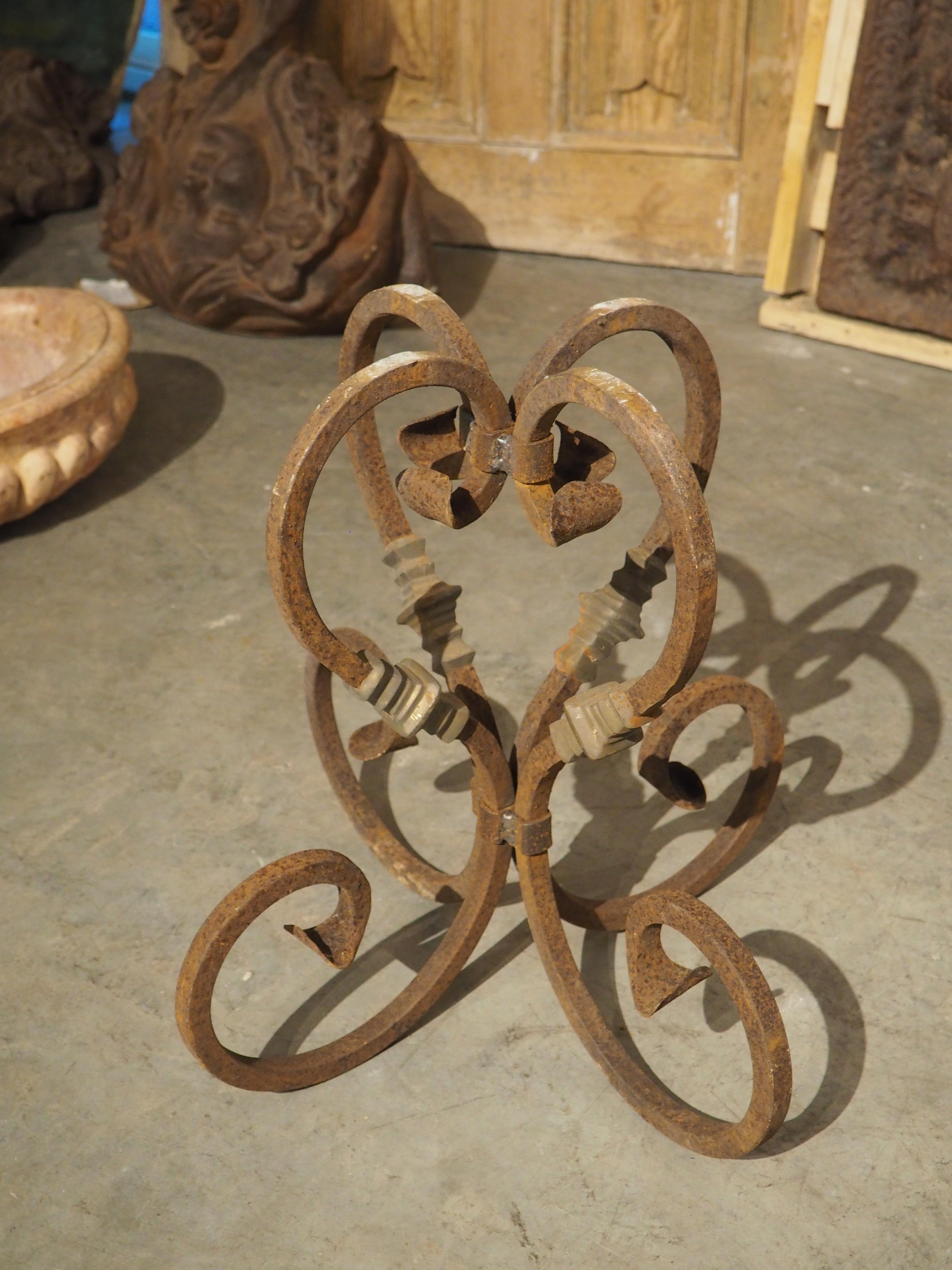 From France, circa the mid-1900s, this pair of cast iron and slate tables would make wonderful additions to a garden or patio. Each cast iron base consists of four S-scrolls, banded at the top above a volute noix and the bottom beneath turned