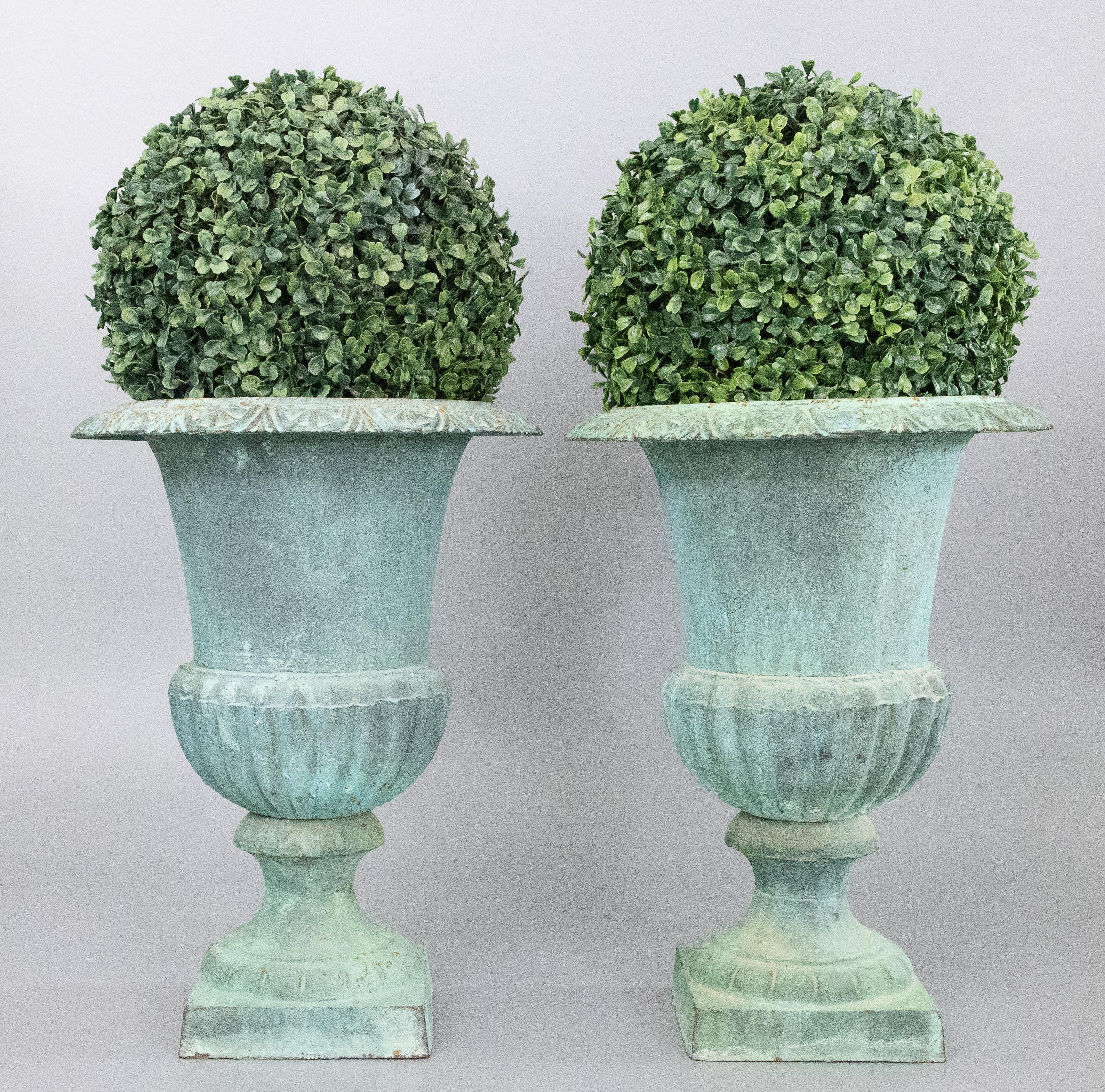 A superb large pair of vintage French Neoclassical style cast iron garden urns or planters in a lovely light verdigris color. These beautiful jardinieres are a nice large size, solid and heavy, and would be fabulous displayed indoors or outdoors.