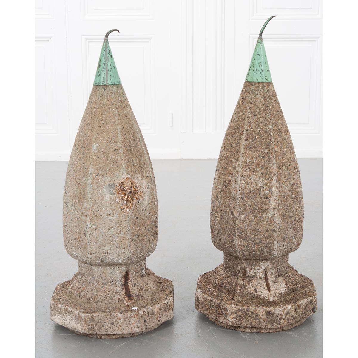 A stunning pair of antique cast stone lightning finials. These beautiful fixtures have an octagonal shape from the base up through the metal tip. They have been aged from decades of exposure to the elements, creating a one-of-a-kind patina. The