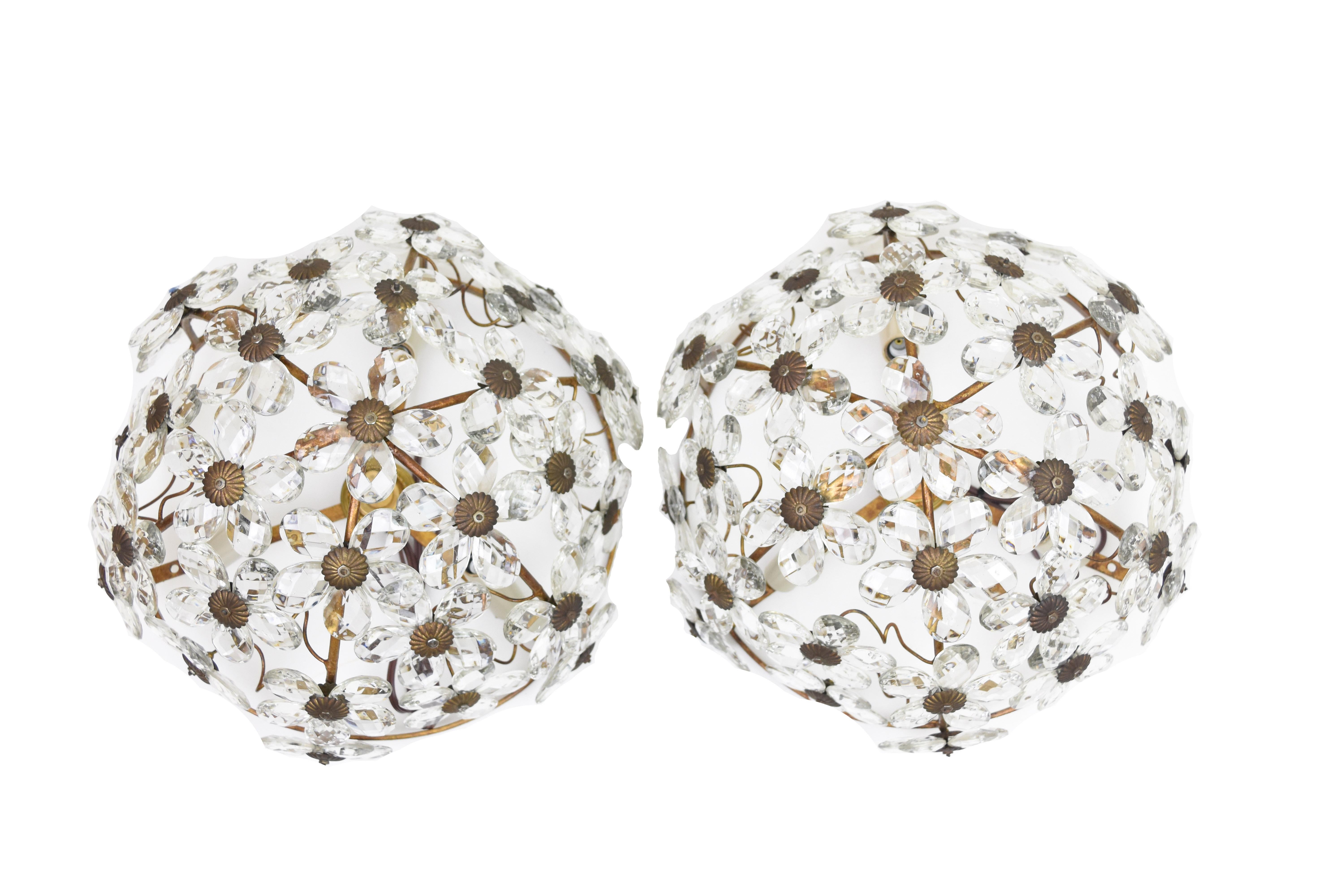 This pair of vintage French crystal ceiling mounted light fixtures features flowers with cut crystal petals. These fixtures are in excellent condition with a beautiful patina. Each fixture has been newly rewired for American use and has three lights.