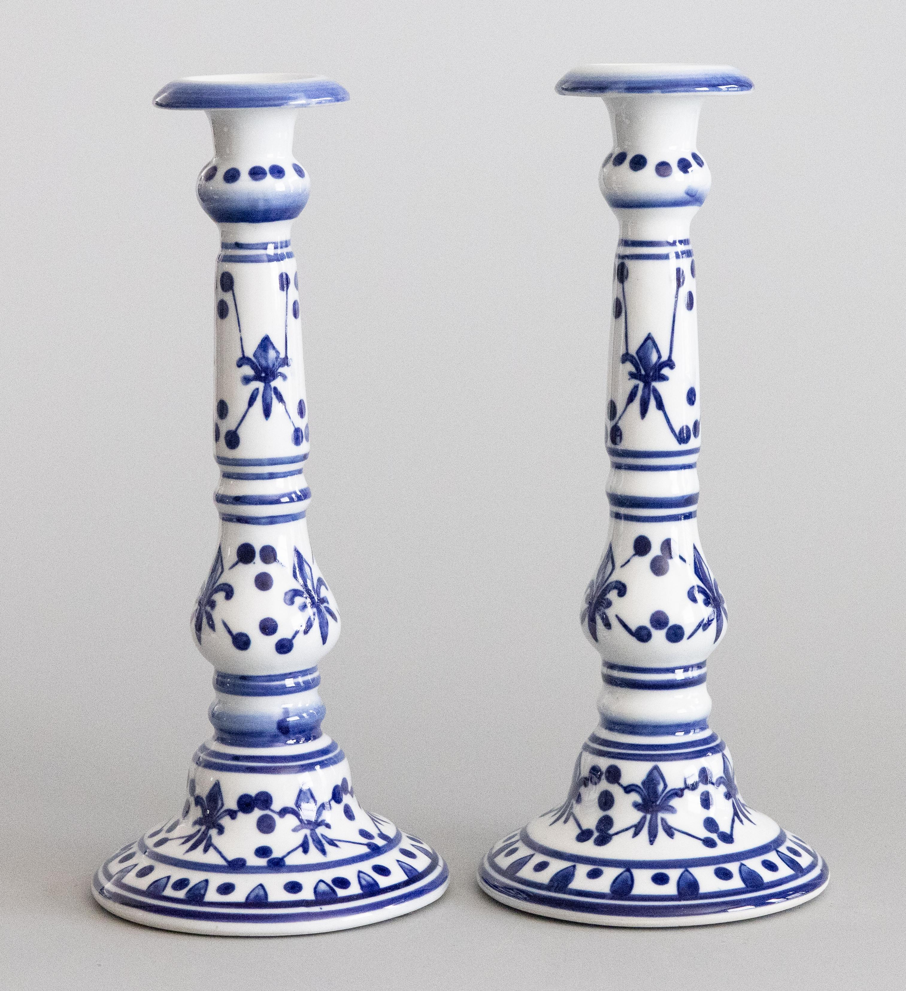 Una bella coppia alta di candelabri vintage in porcellana blu e bianca in stile Delft provenienti dalla Francia. Nessun marchio di fabbrica. Questi bellissimi portacandele sono di grandi dimensioni, dipinti a mano con un elegante motivo geometrico a