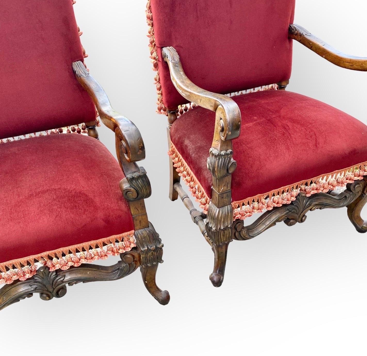 Pair of carved French Louis XIII style Fauteuils or armchairs, with gracefully scrolled arms, high backs and generous seats (and seat heights of 20”) resulting in uncommon comfort.
The lower apron was pierce-carved in a stylized anthemion theme,