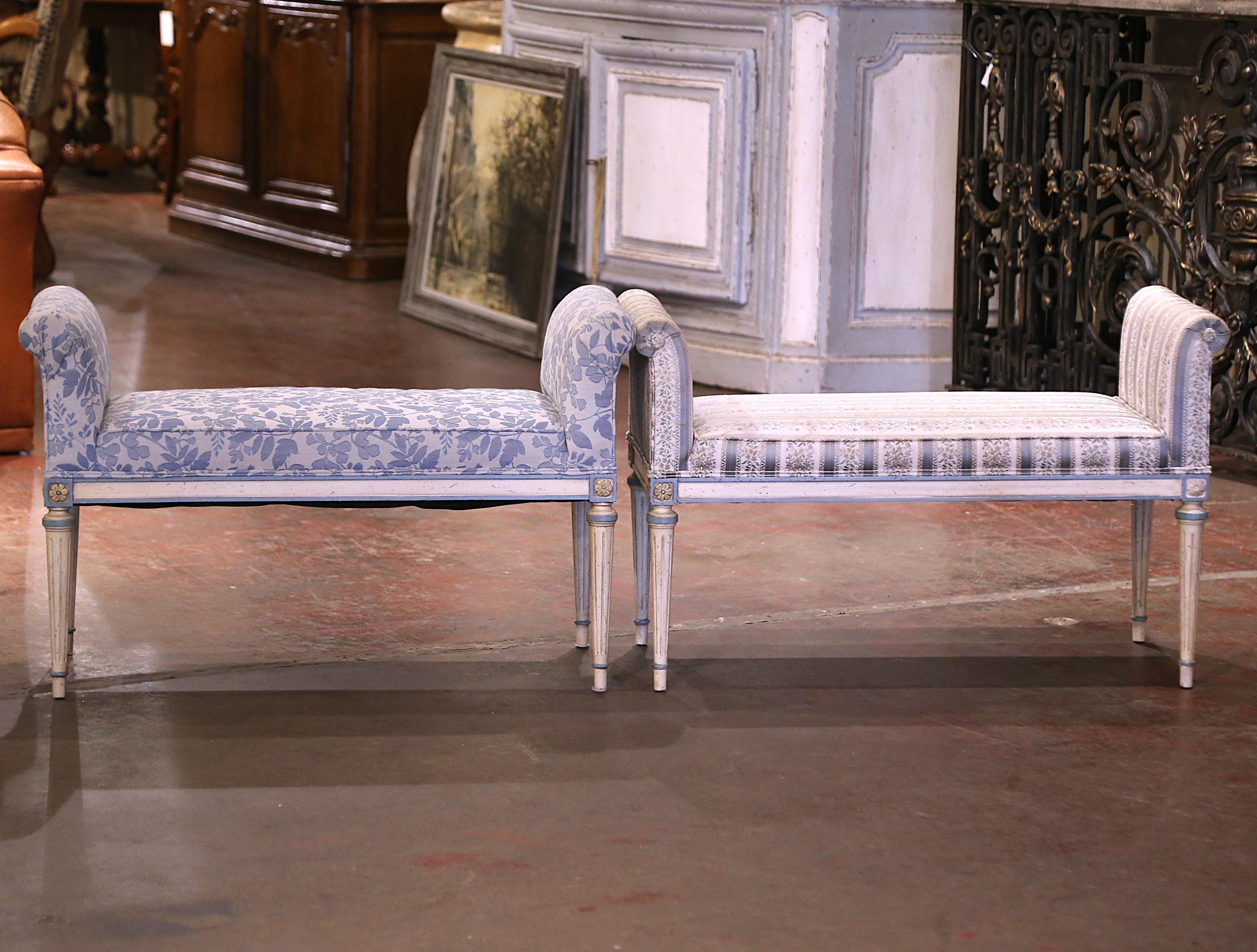 Cette élégante paire de bancs en bois peint de style Louis XVI a été fabriquée dans le nord de la France vers 1980. Chaque banc repose sur des pieds finement sculptés, effilés et cannelés, décorés de motifs floraux aux épaules. Les bancs sont dotés