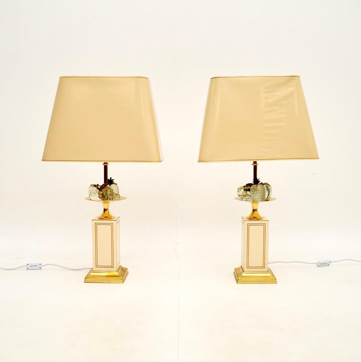 A smart and very stylish pair of vintage French table lamps by Le Dauphin, dating from the 1970’s.

The quality is superb, they have a gorgeous design, with cream bases, brass accents and decorative clear acrylic fruit baskets on each lamp. They