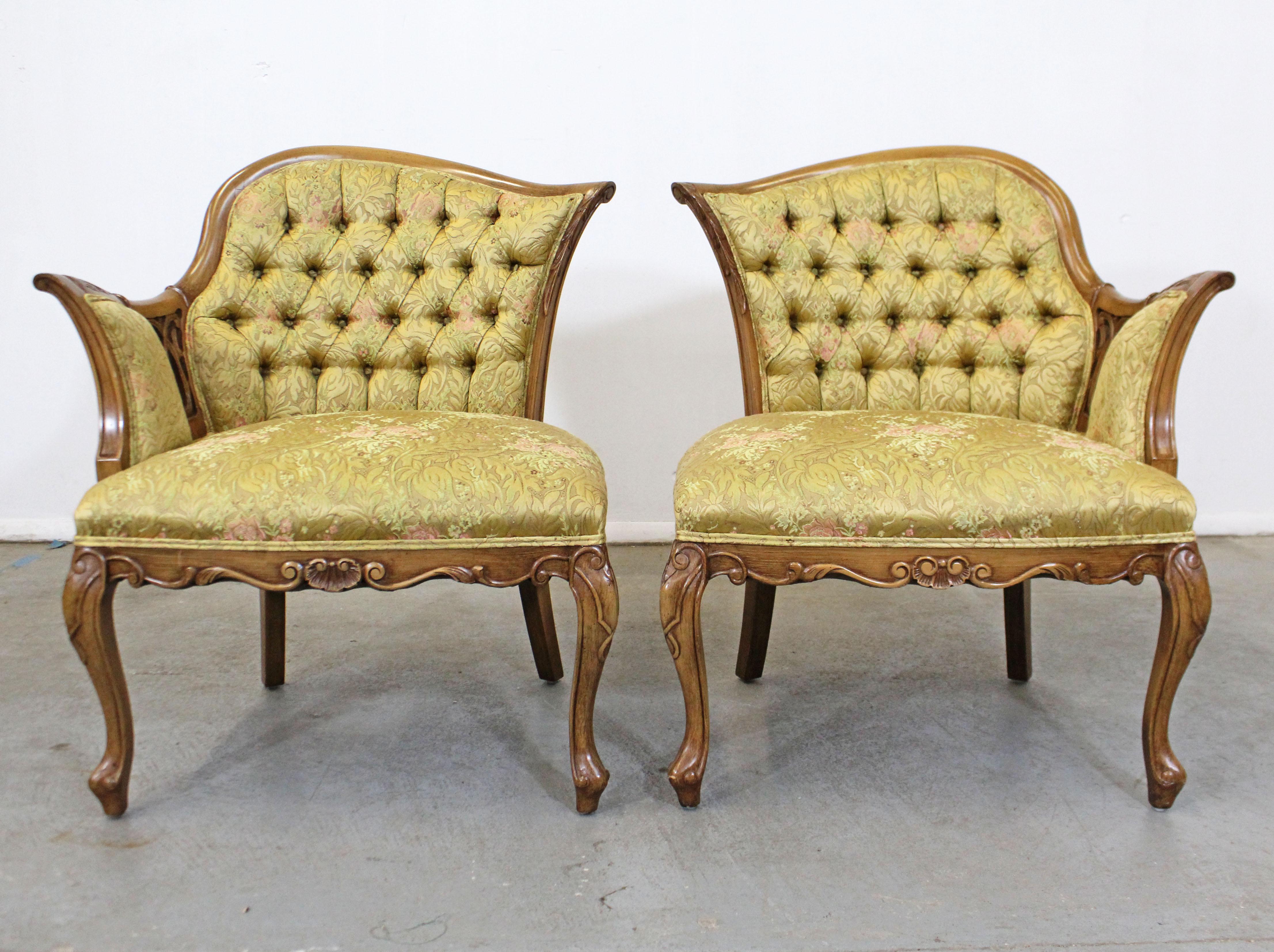 Offered is a pair of vintage French fireside chairs with beautiful tufted upholstery with a floral print. Features beautifully carved arms and legs with floral upholstery. This chair design dates back to the 17th century meant for women wearing hoop