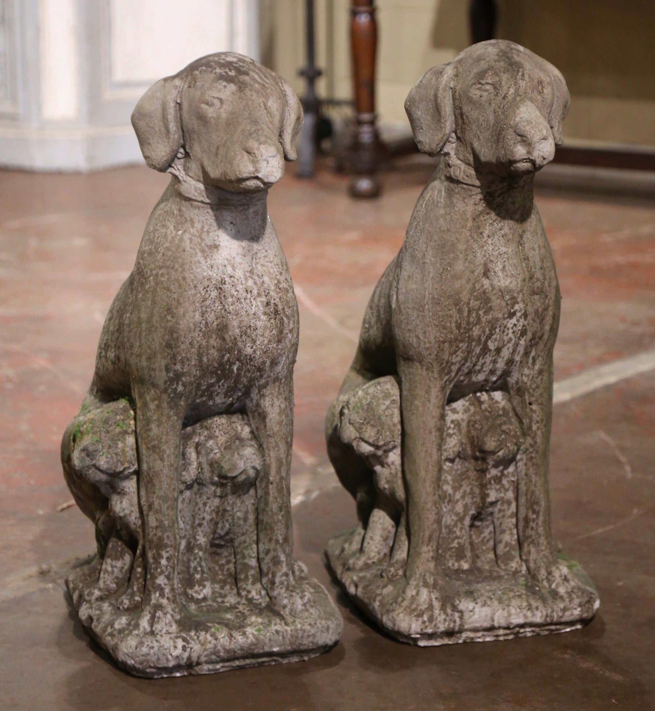 Tallados en piedra, los altos labradores se asientan sobre una base plana rectangular; sentados sobre sus patas traseras, ambos perros tienen una expresión orgullosa adornada además con un collar alrededor del cuello y dos cachorros escondidos bajo