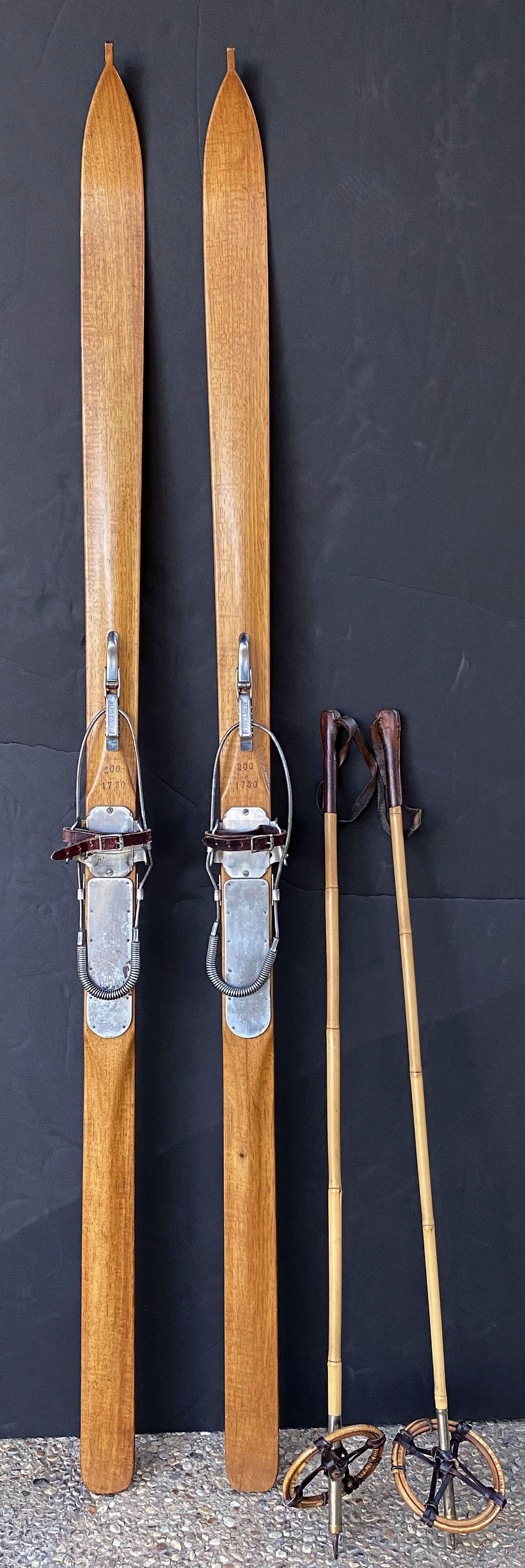 A fine pair of vintage French wooden skis with bamboo skiing poles of the style that were very popular from the mid-1930s to early 1950s.

Marked: Alpa Cable.

Great for a ski lodge or chalet!