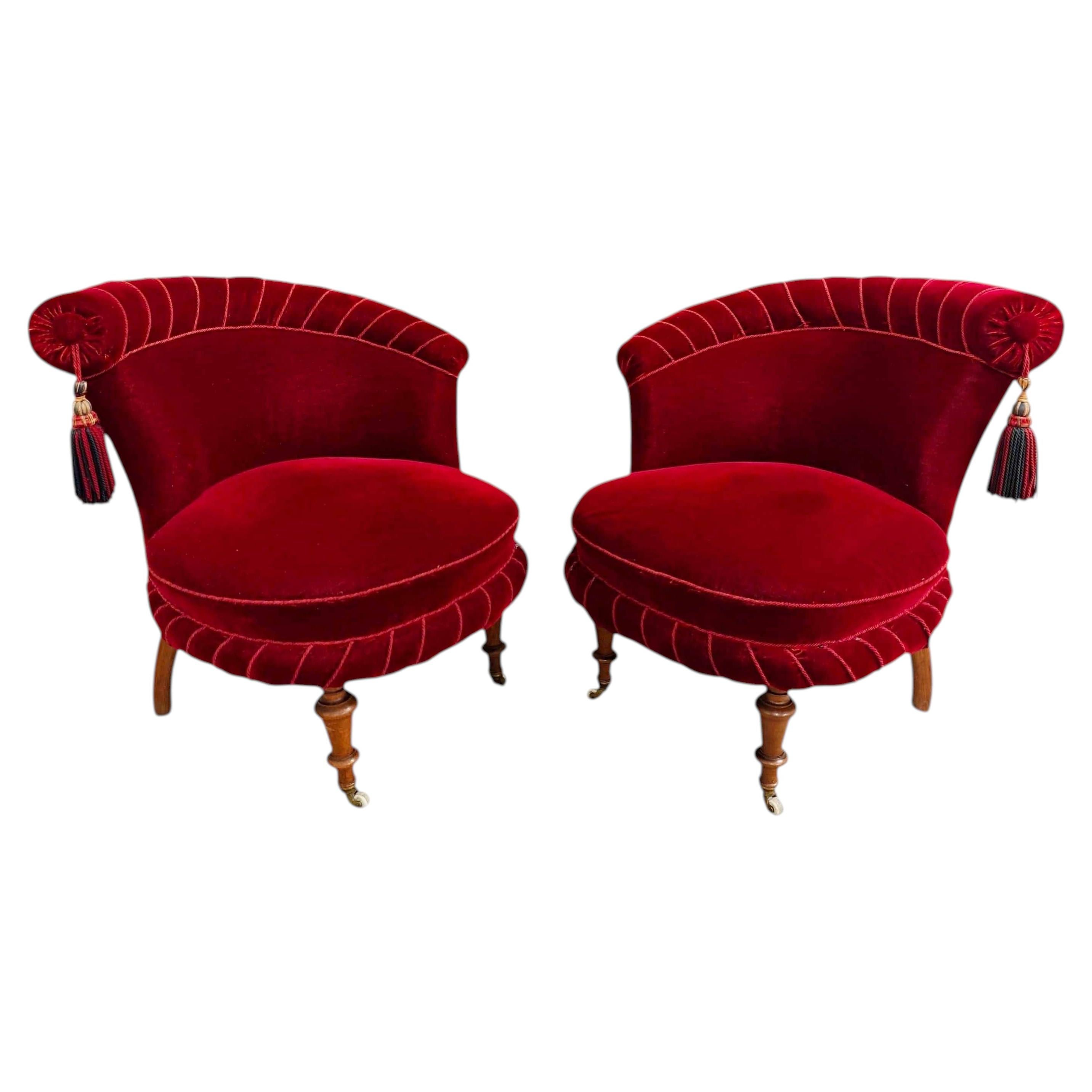 Paire de fauteuils-chaussons vintage en velours rouge grenat, avec roulettes en laiton et pieds en bouleau