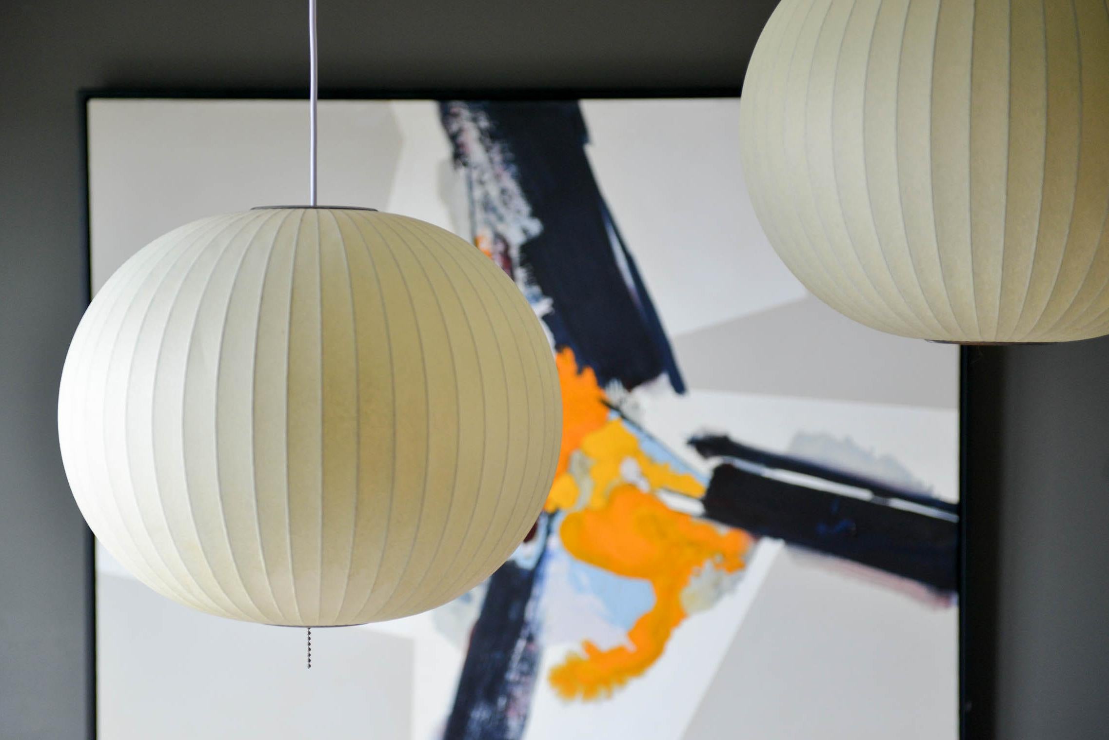 Pair of vintage George Nelson round bubble pendant lights, circa 1965. Very good original condition with no holes or cracks, new wiring and beautiful warm patina. Some of the finest vintage lights we have come across. Medium size is 19