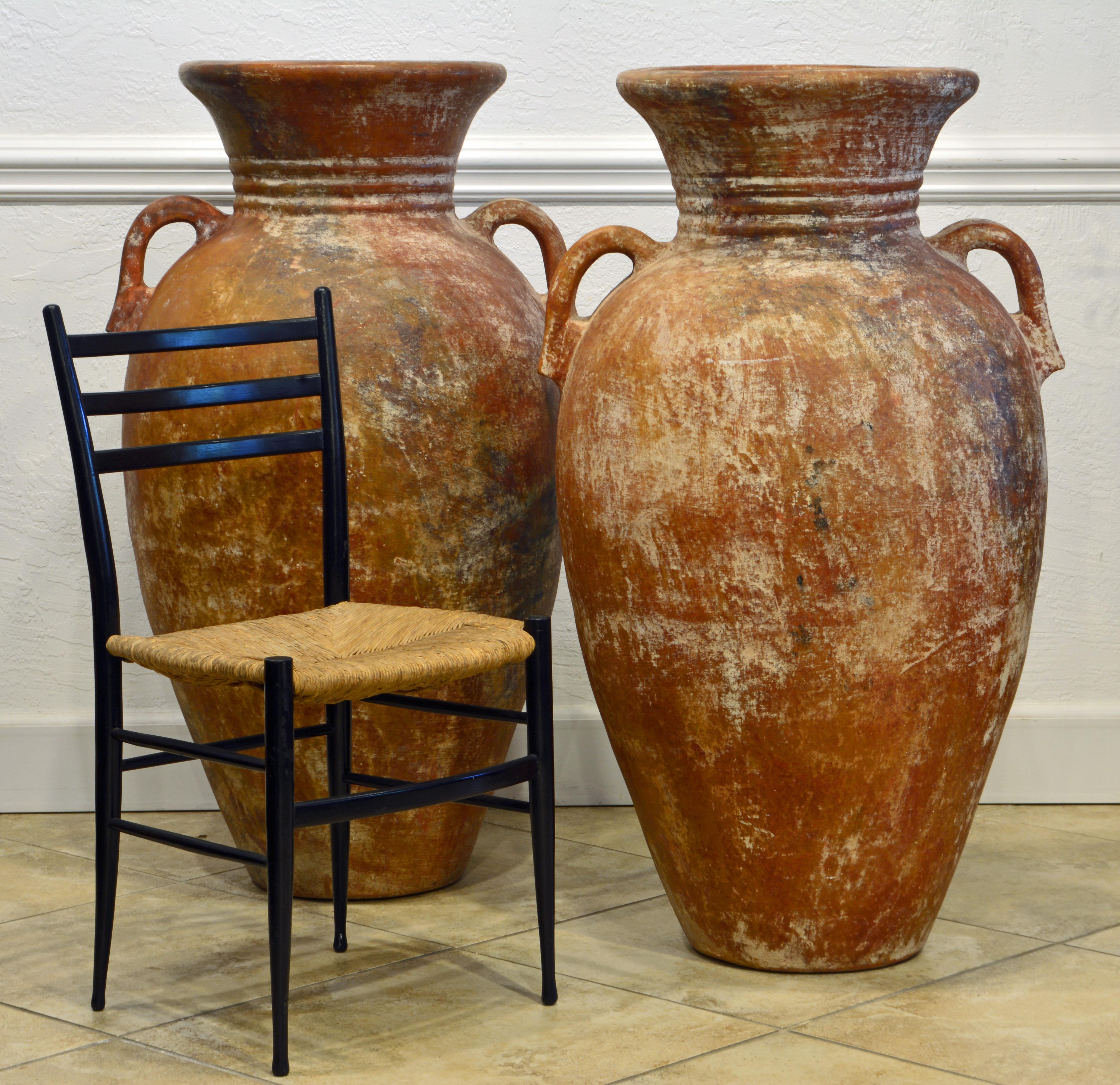 Standing 43 inches tall these Mediterranean terracotta jars will be equally impressive both outdoor and in the home. The jars feature sculpturally flared tops and ribbed necks above generously dimensioned bodies with strong handles. Measure: H 43 in.