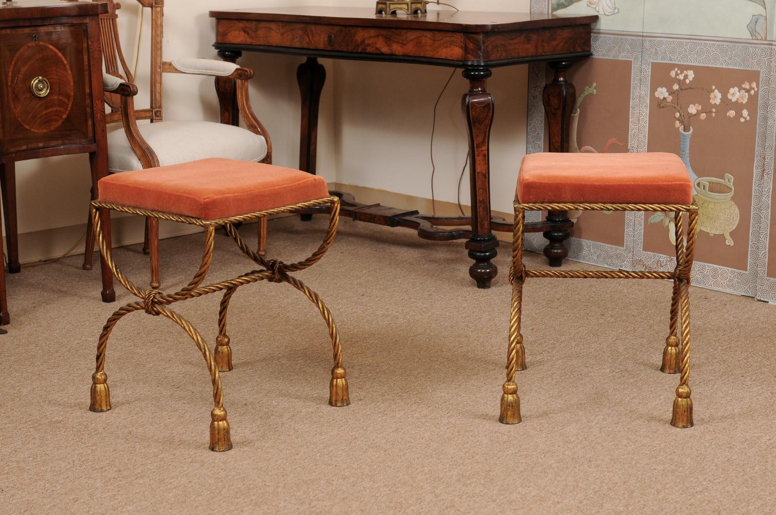 Pair of vintage gilt iron tassel benches with pink velvet seats.