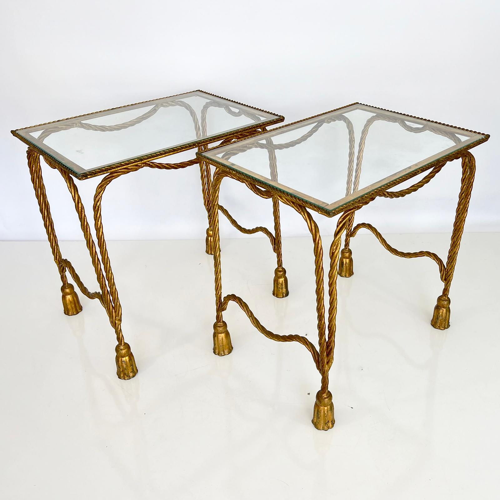 Pair of end tables, by Niccolini, each having a rectangular glass top, raised on four cabriole legs fashioned as rope, joined by matching, shaped stretcher, ending in tassel feet. 

Stock ID: D3448.