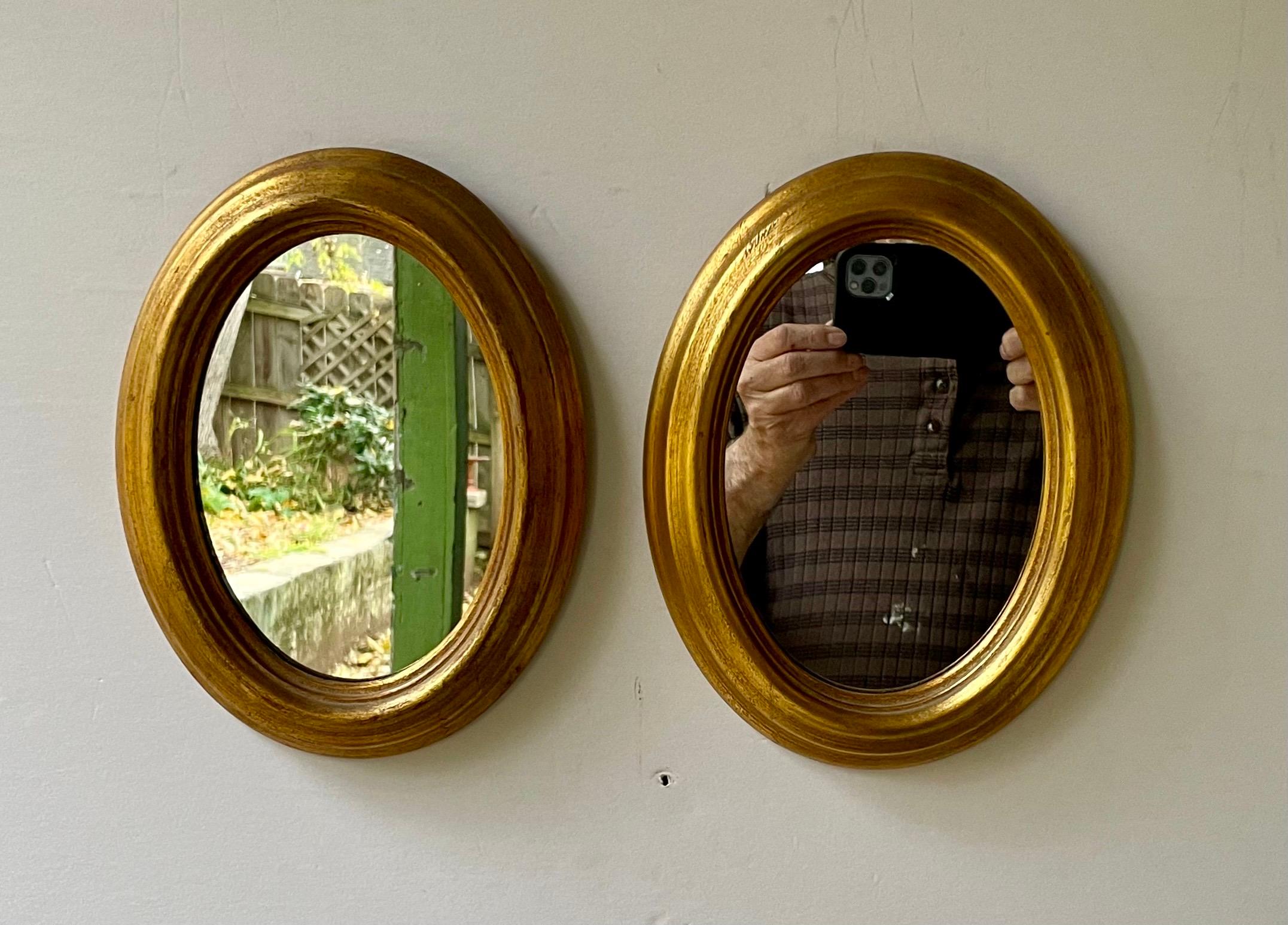 Paire de miroirs ovales italiens dorés. Chaque miroir mesure 9