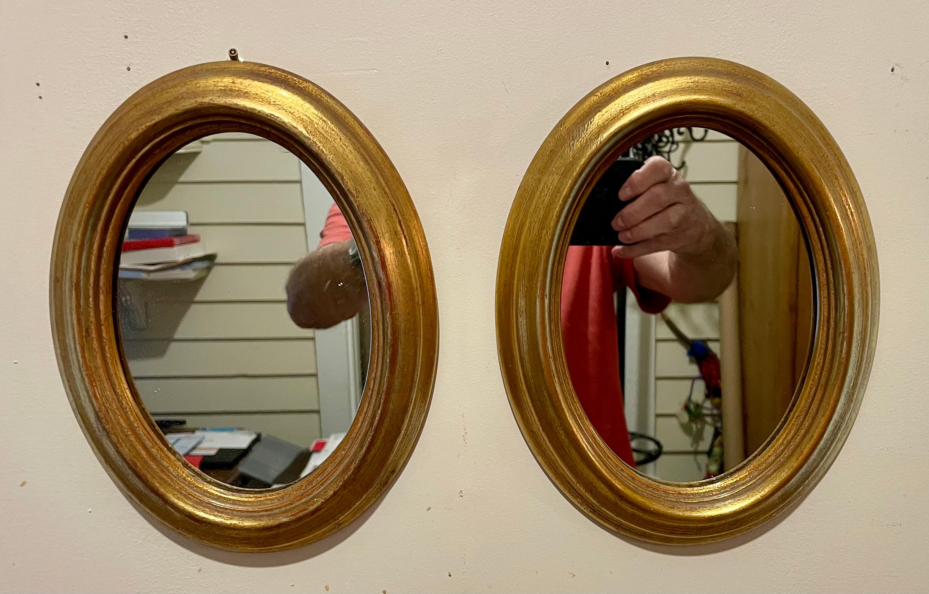 Paire de miroirs ovales italiens dorés. Chaque miroir mesure 9