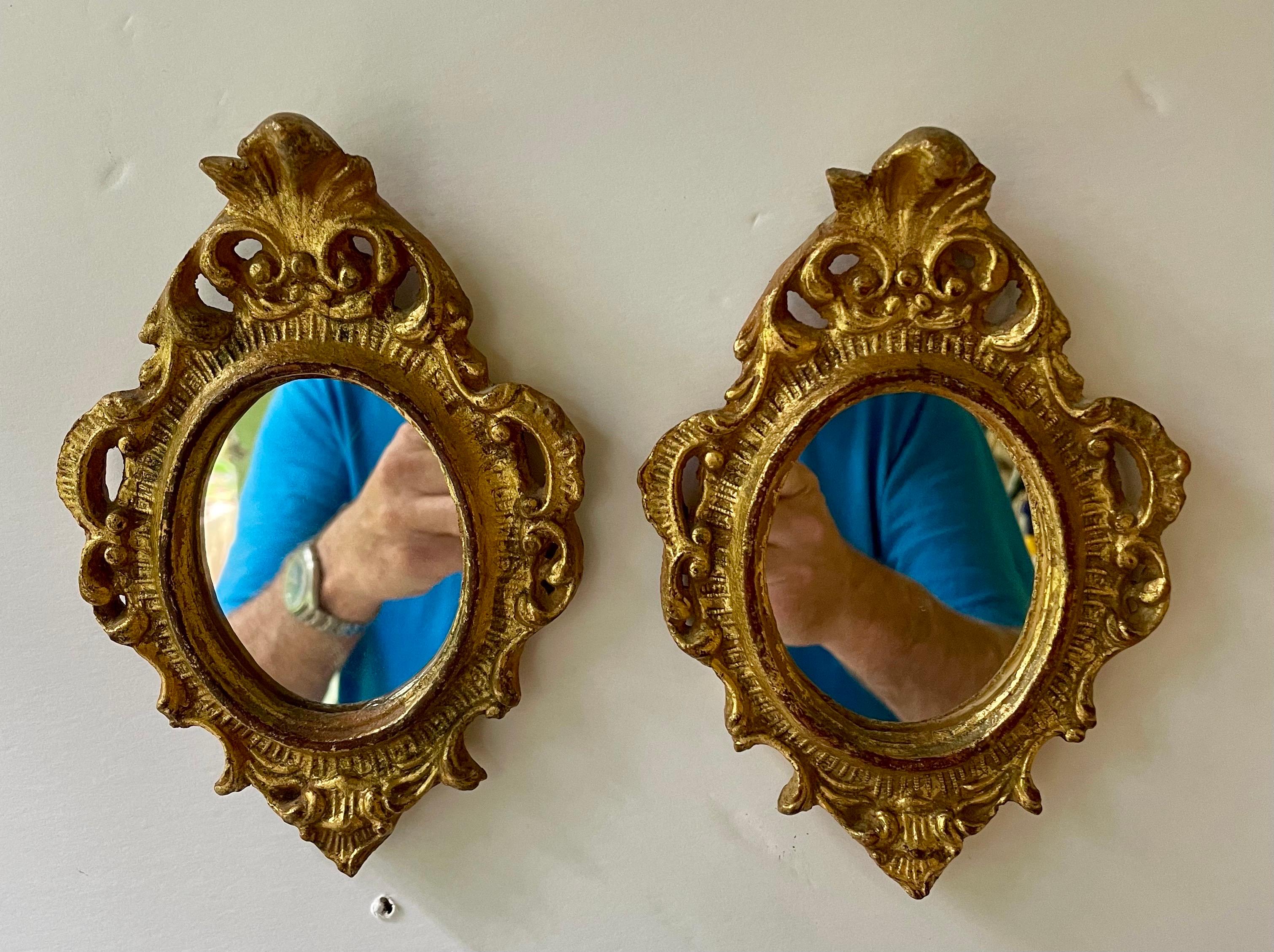 Grande coppia di specchiere italiane Florentine in legno dorato in stile Hollywood Regency. Buone condizioni con specchio sostituito di recente. Misura 7,5