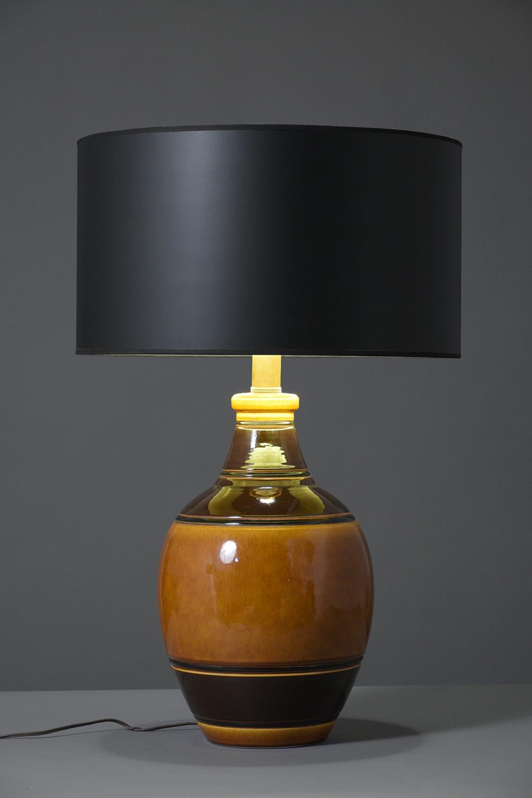 A vintage pair of 1960's table lamps that are hand-crafted out of caramel & brown color ceramic and are in working condition. These fabulous lamps have been professionally restored, feature new black shades, and the ceramic bases have a beautiful