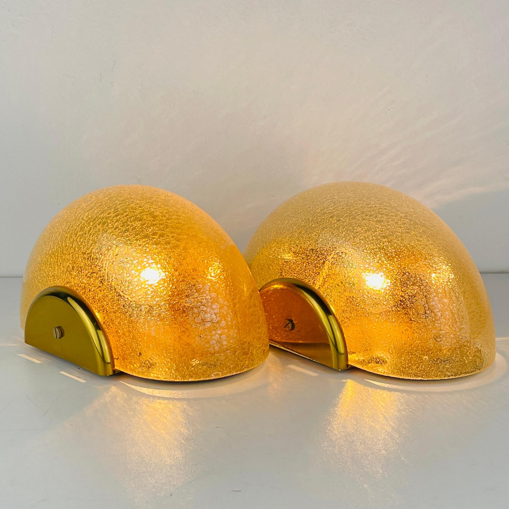 Elevate your space with a pair of charming gold Murano glass sconces, crafted by F. Fabbian in Italy during the 1970s. Despite their age, these sconces have been perfectly preserved, showcasing their original details with no cracks or chips. Fully