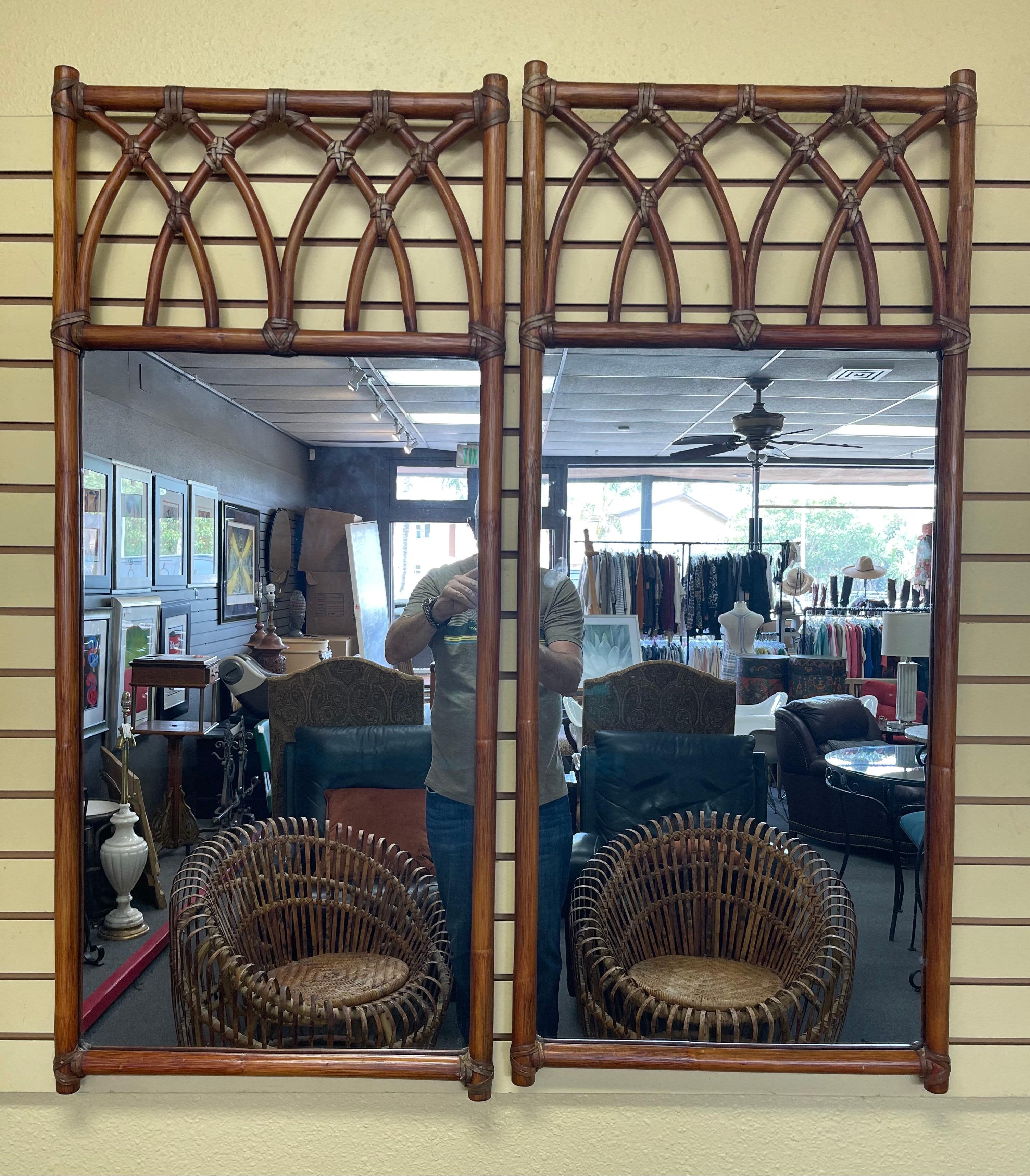 Paire de miroirs vintage en bambou de style gothique par McGuire Furniture Co. de San Francisco, circa 1970. Les miroirs sont recouverts d'une arche gothique unique (l'une des caractéristiques de la marque) et sont reliés par des bandes de cuir