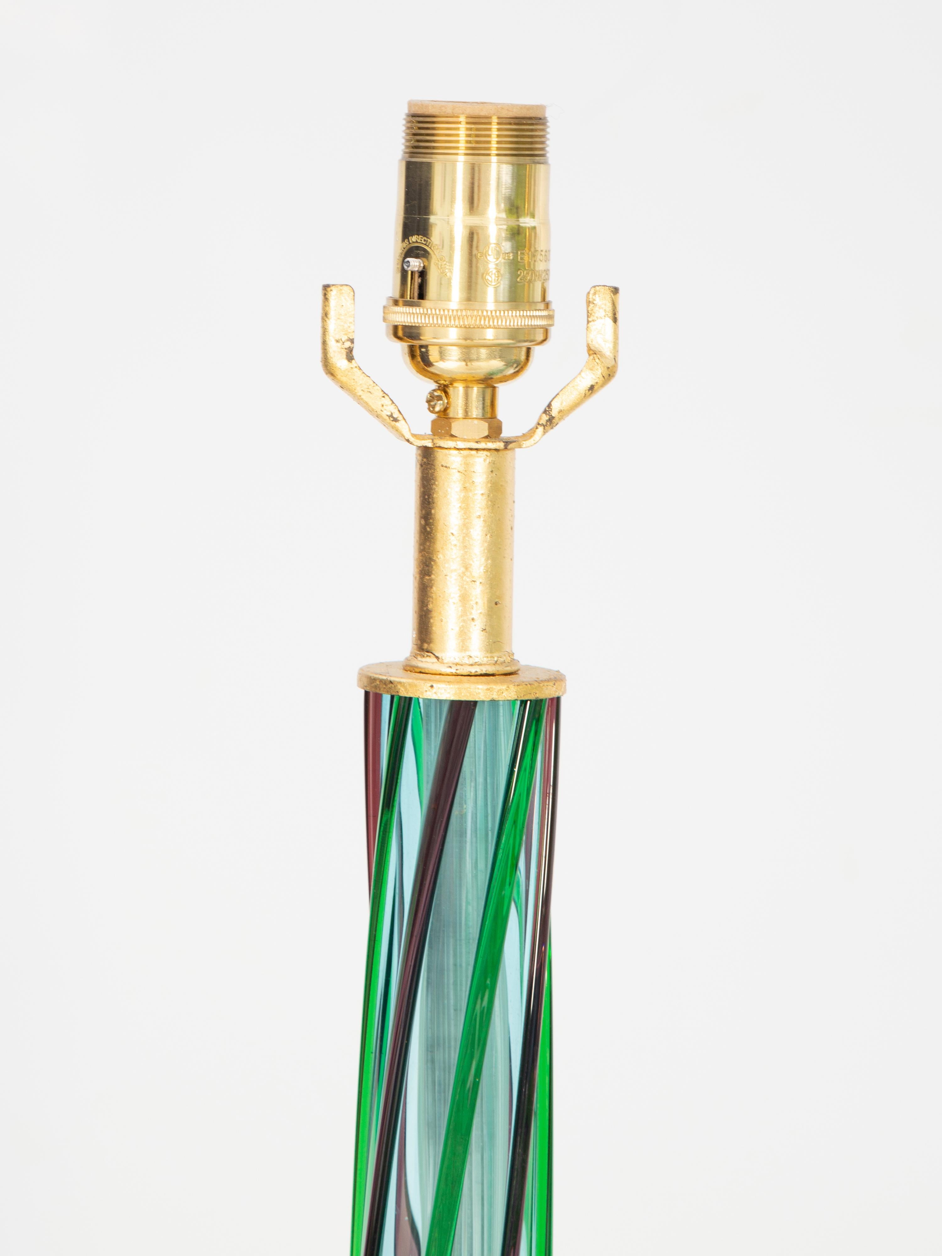 Paire de lampes en verre de Murano soufflé à la main, chacune ayant une forme de vase bulbeux en bleu pâle avec des tourbillons verts et violets, sur des bases rondes, graduées et dorées. 

Diamètre de la base : 6,75 pouces