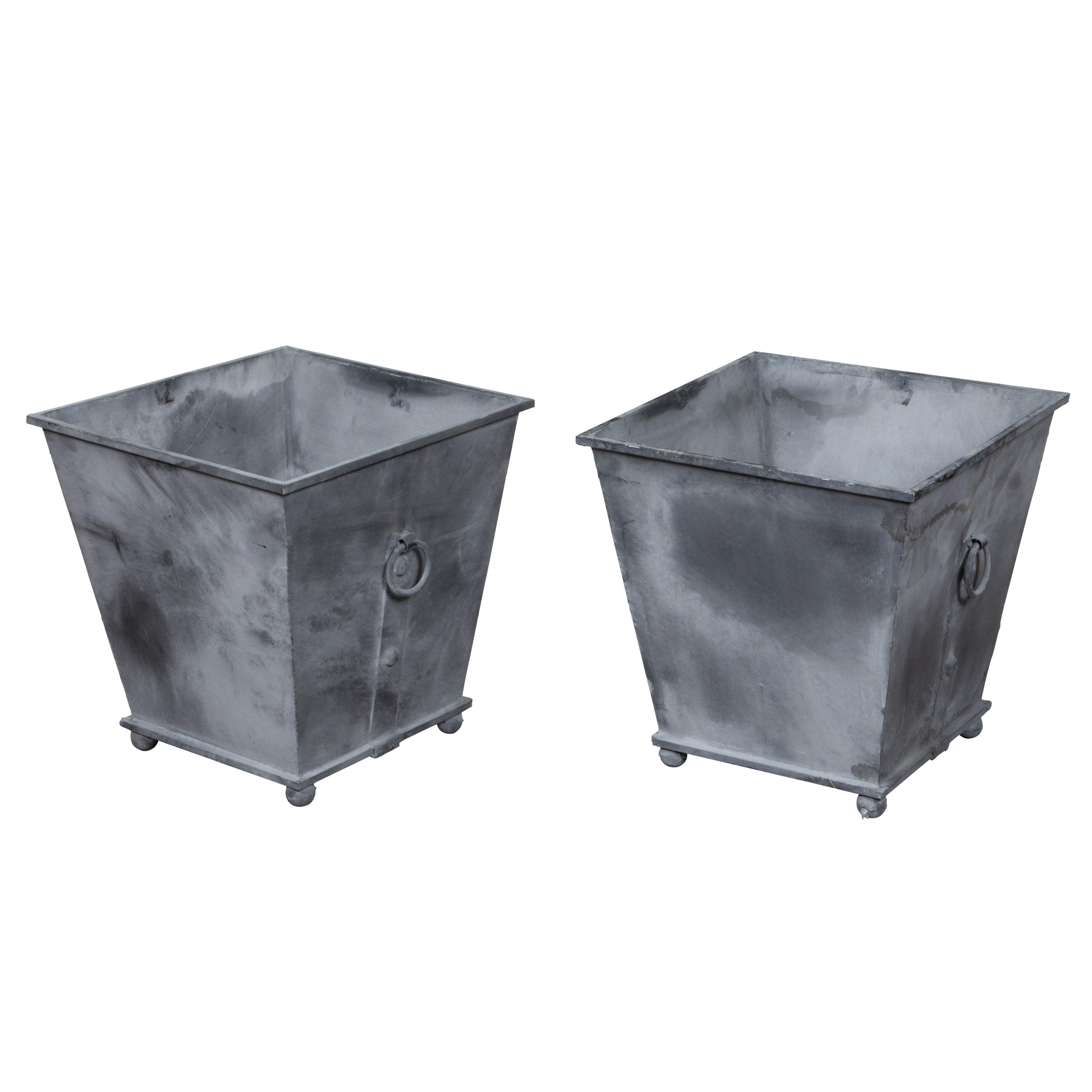 Patinated Pair of Vintage Grey Metal Planters with Tapered Lines, Ring Pulls and Ball Feet For Sale