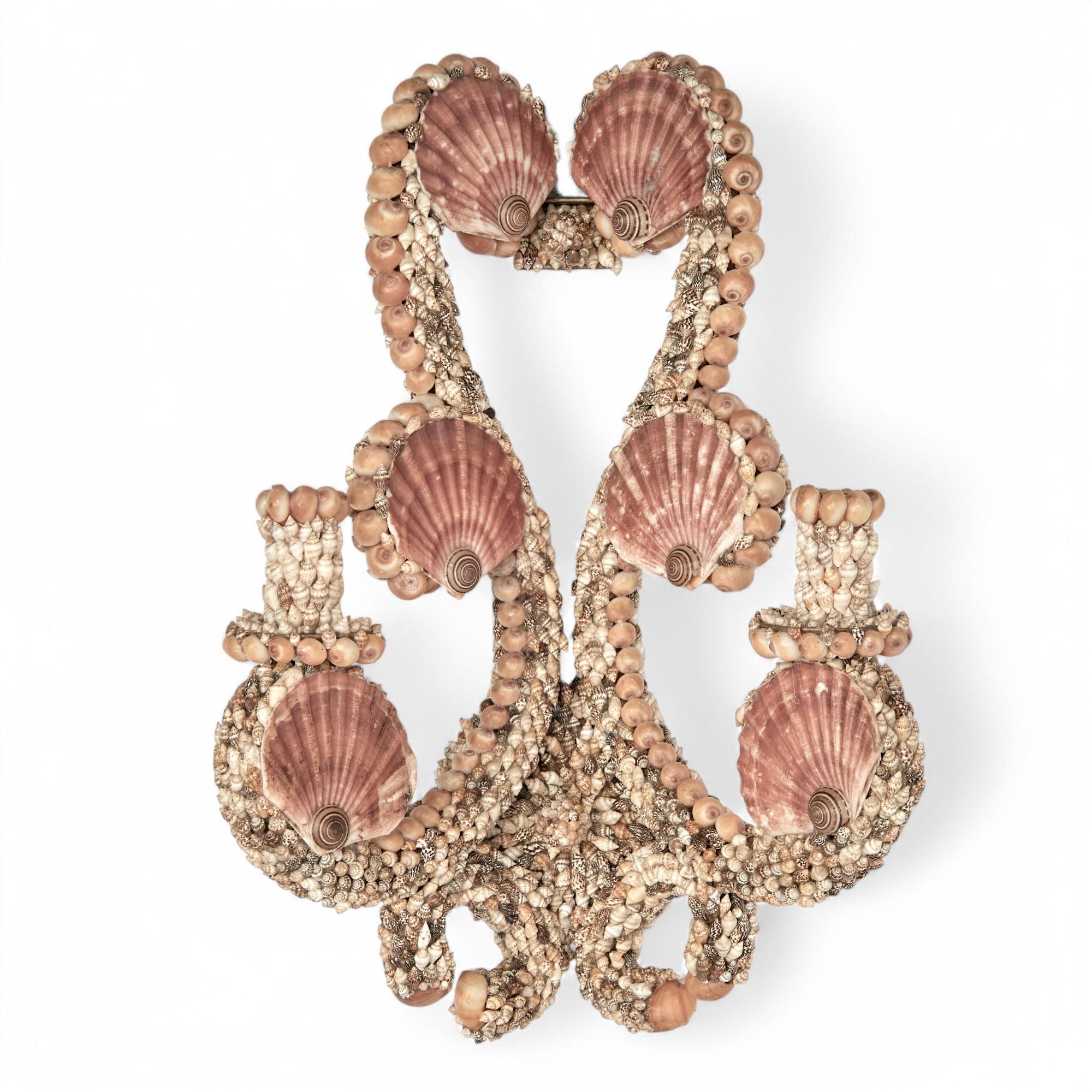 Whimsical pair of Palm Beach regency wall sconces ambitiously decorated in a fantasy composition of exotic seashells over a metal frame in a two light classical form.