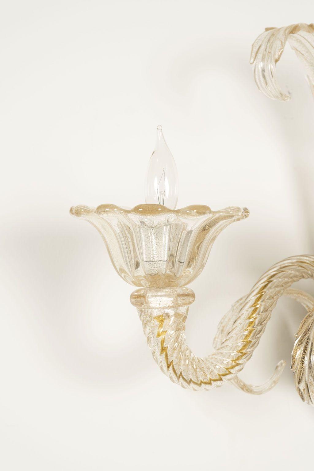 Pair of vintage hand-blown Murano clear sconces. Clear hand-blown Murano glass with subtle gold flecks. Wired for use within the USA - includes back plate. Each arm accommodates a candelabra-size bulb. Sold together priced $4,400 for the pair.