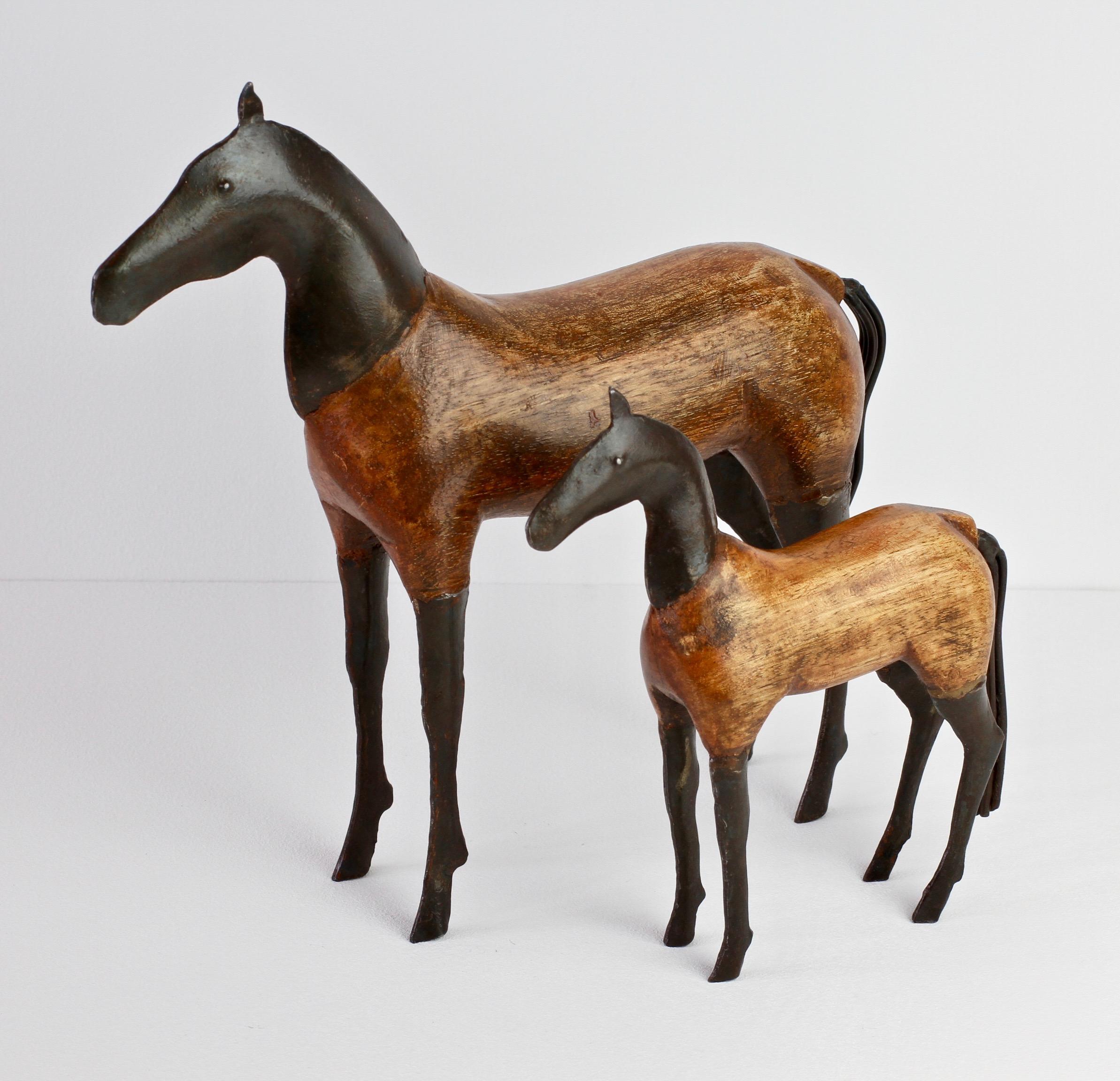 Wooden horse sculptures - probably Scandinavian in origin and made circa 1980s. Featuring bodies, beautifully shaped and hand-carved with legs, heads and tails all made of forged blackened metal. Perfect for any horse enthusiasts or lovers of the
