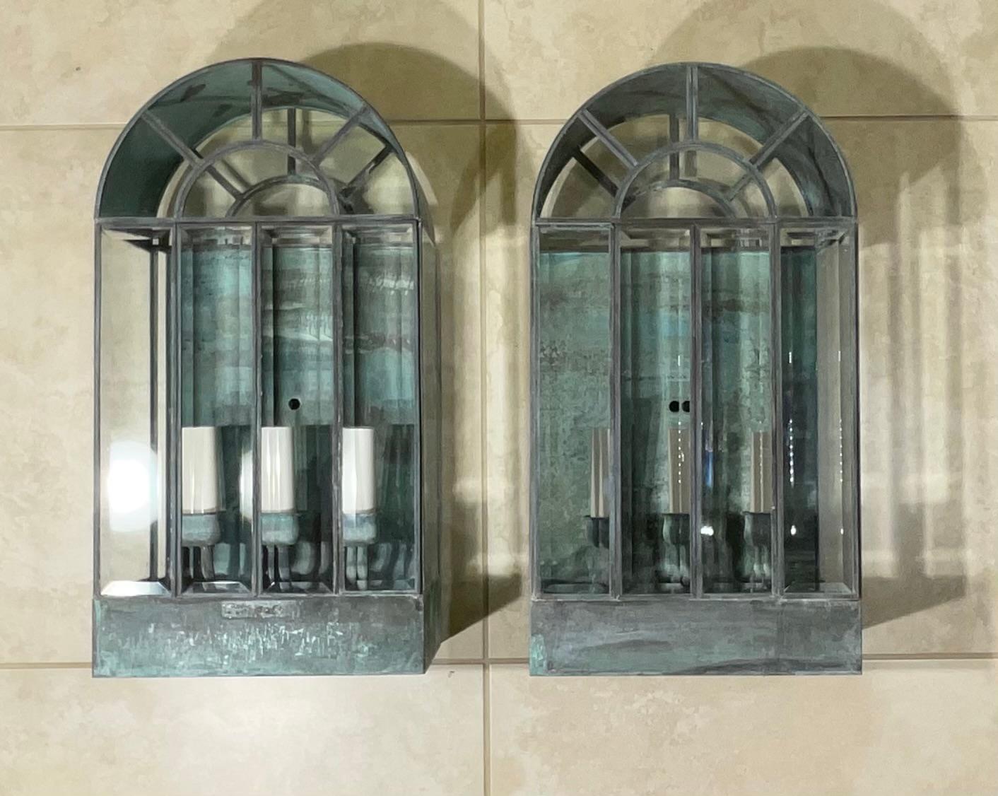 Pair of wall hanging lantern arch style made of solid brass, quality workmanship, bevelled glass, electrified with three 40/watt lights each lantern, beautiful patina great light exposure. Working and ready to use.
Suitable for wet locations.