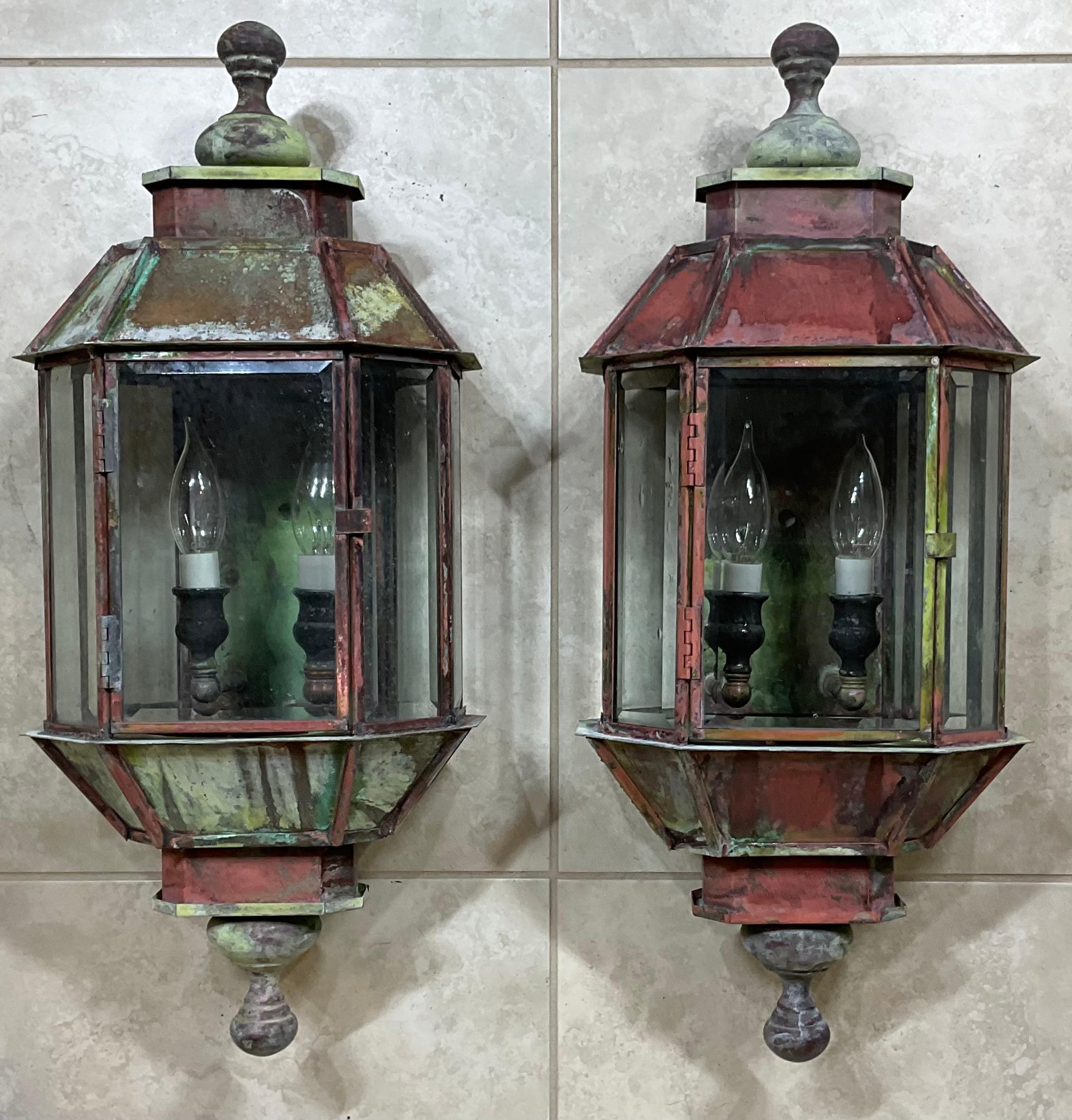 Exceptional pair of wall hanging lantern made of solid copper-brass, quality workmanship, seven sides of bevelled glass, electrified with two/60 watt lights each, beautiful patina Great light exposure. Working and ready to use.
Suitable for wet