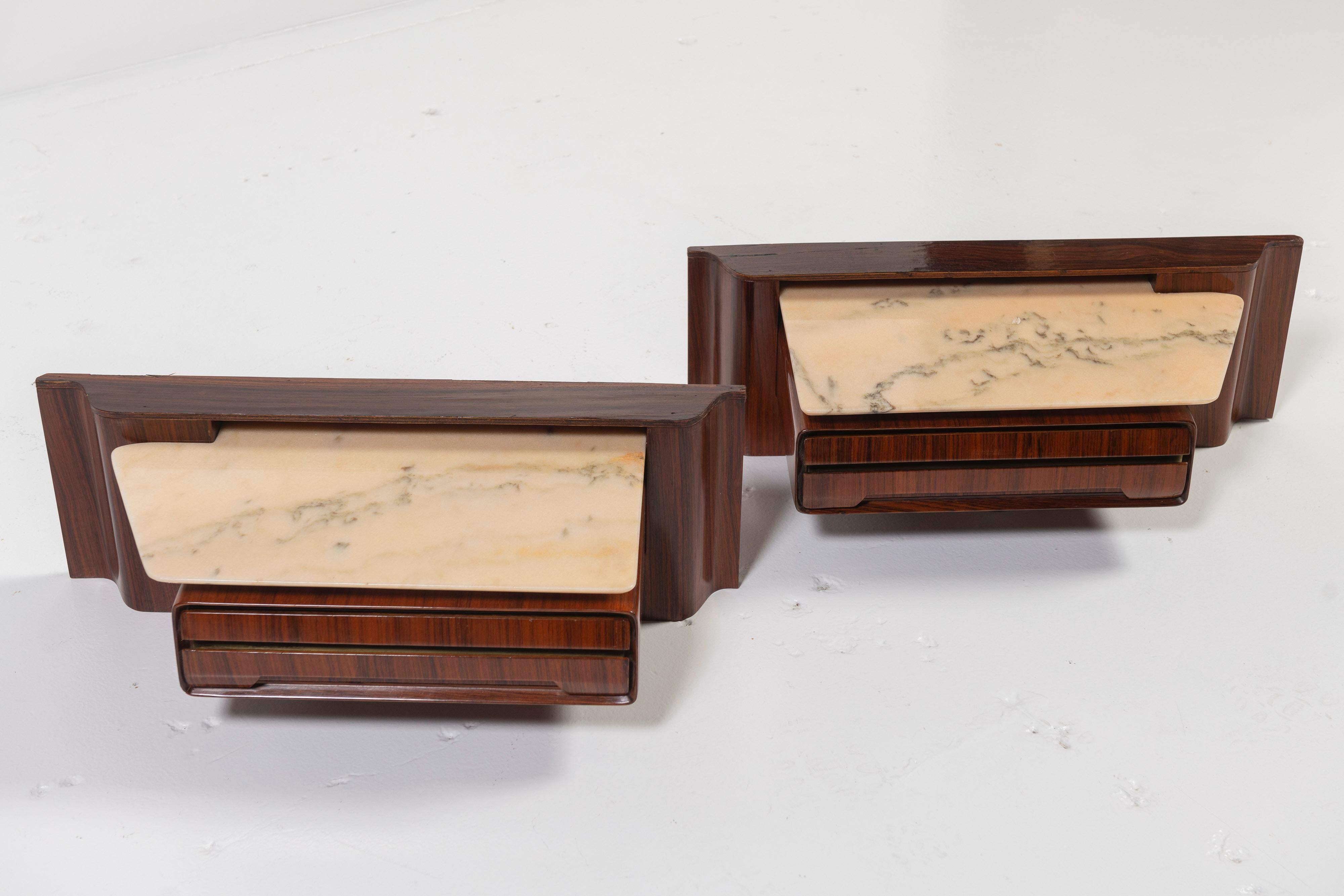 Sold as a pair, these bedside nightstands, likely in rosewood, hang comfortably on the wall, and contain a single drawer each as well as an alabaster shelf with rounded edges. Sleek and compact, these Italian designed units complement the bed and