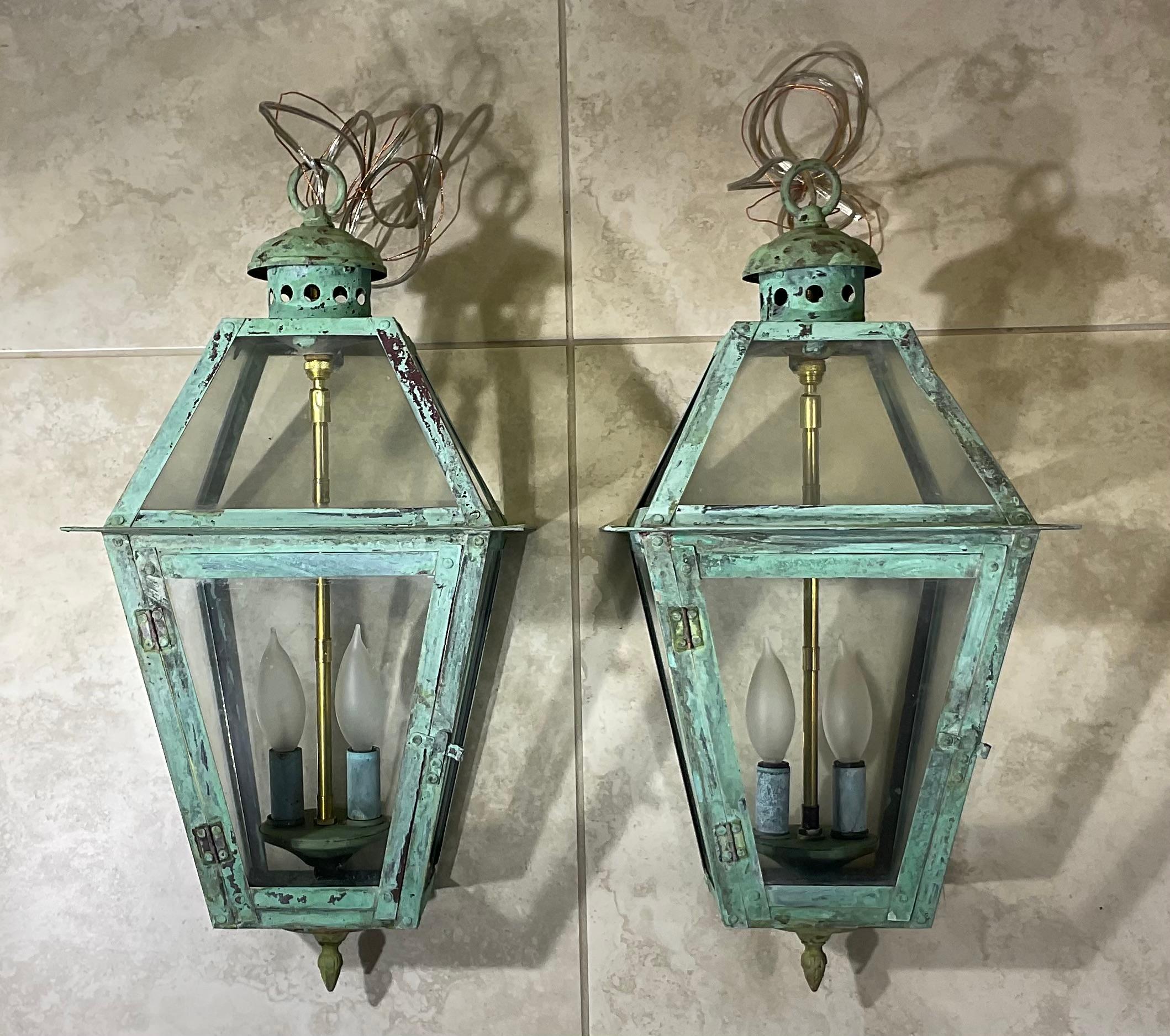 Pair of lantern made of solid copper , originally  was gas lantern and converted to be electric hanging light . Two 40/watt light,  great look ,beautiful oxidized patina .
 Suitable for wet location.
Canopy and chain included.