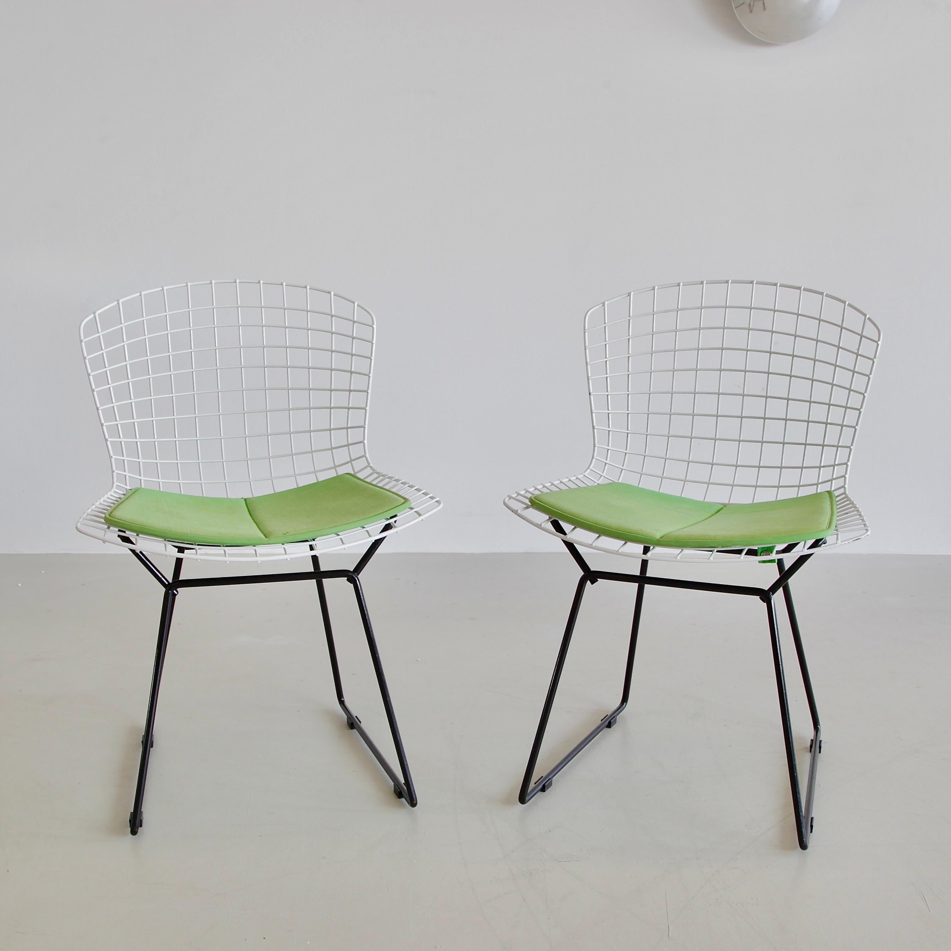 Pair of side chairs, designed by Harry Bertoia. U.S.A., Knoll International, 1970s.

Vintage pair of black and white side chairs with green coloured pads. The Bertoia Diamond Armchair, originally designed in 1952, this pair dates from the 1980s,